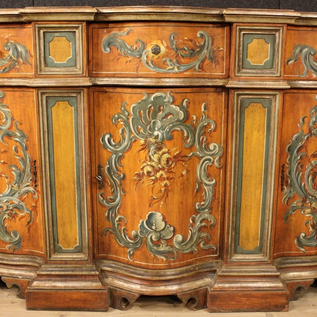 Venetian sideboard of the mid-20th century. Italian furniture in finely carved, lacquered and painted wood with floral decorations. Sideboard with three doors and three drawers, of large capacity and service. Furniture provided with a working key
