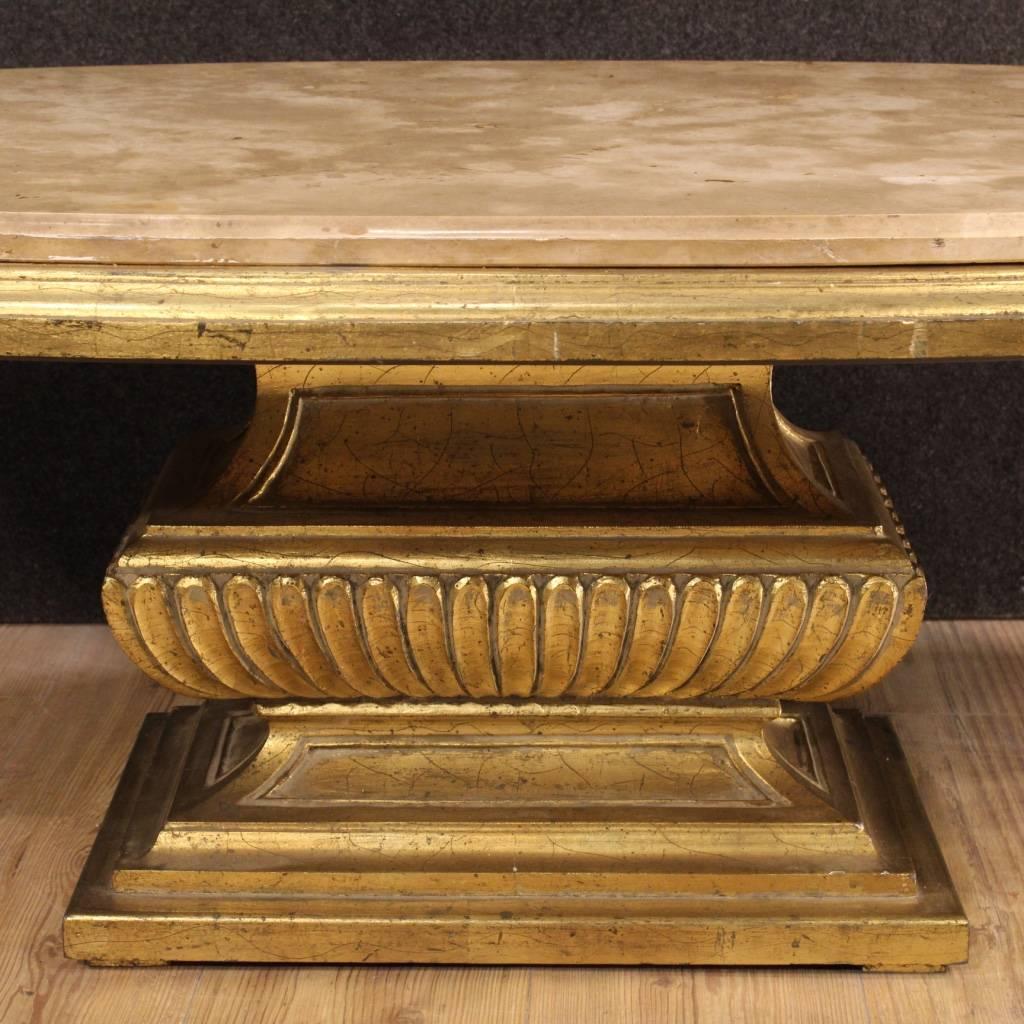 Stylish Italian coffee table of the second half of the 20th century. Furniture in nicely carved and gilded wood, of beautiful line and good taste. Living room coffee table of oval form with original marble top floor, in perfect condition. Furniture