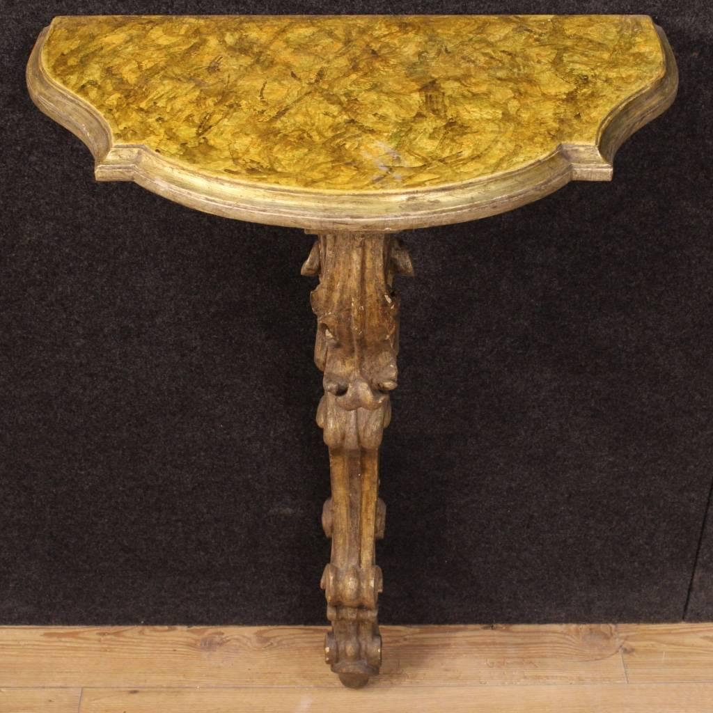 Elegant Italian console table of the mid-20th century. Furniture in ornately carved, lacquered and gilded wood, of great taste and nice decoration. Console to fix to the wall for a perfect stability with top in lacquered faux marble wood, of good