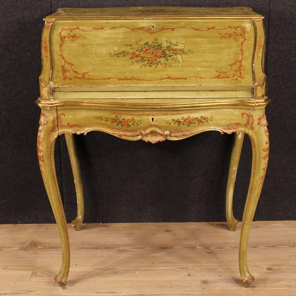 Beautiful Venetian bureau of the mid-20th century. Furniture in ornately carved, lacquered, gilded and hand-painted wood with floral decorations, of very pleasant and fabulous decor. High leg bureau finished for the center equipped with a fall-front