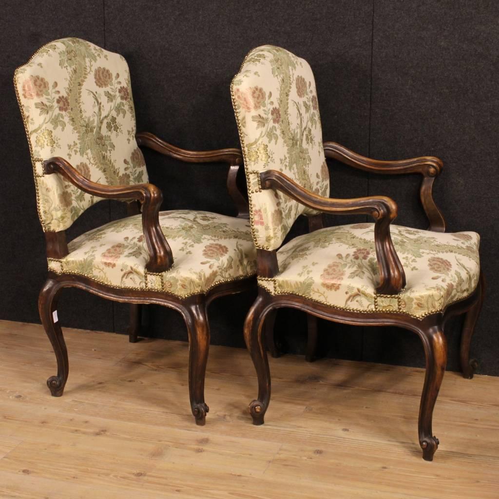 Beautiful pair of Italian armchairs of the mid-20th century. Furniture in nicely carved walnut dye wood, of beautiful decoration. Armchairs of good comfort with curved arms and legs with carved curled legs. Padding and fabric in good condition.