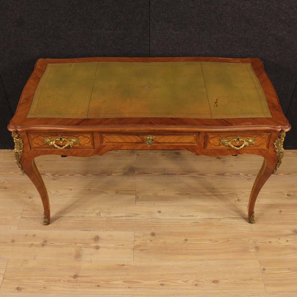 Stylish French writing desk of the first half of the 20th century. Desk nicely inlaid in wood of rosewood and walnut, richly decorated with gilded and chiseled bronzes. Writing desk finished for the centre with three drawers, of good capacity, two