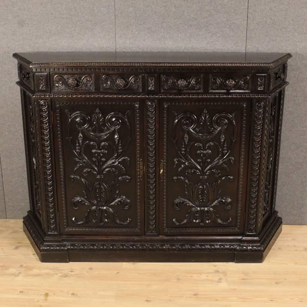 Great Italian sideboard of the mid-20th century. Furniture in ornately carved wood in Renaissance-style. Notched sideboard with two doors and two frontal drawers of large capacity. Wooden top in character of great size and service. Furniture