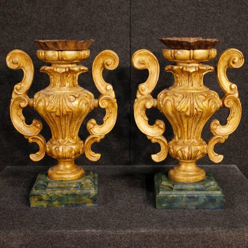 Pair of Italian candelabras of the 20th century. Objects in carved, gold and lacquered faux marble wood. Candlestick of beautiful decoration that can be easily inserted at different points of the house. They show signs of wear and color drops,