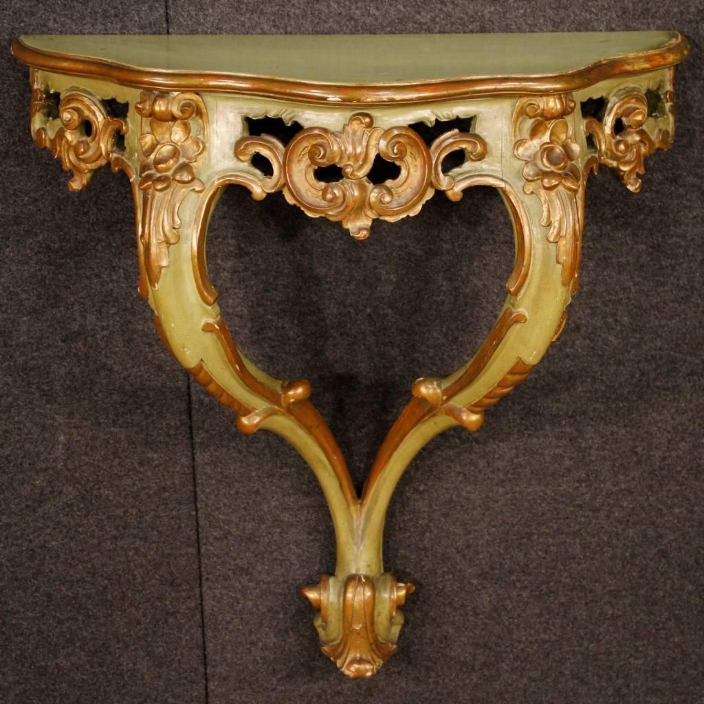 Pair of Venetian console tables of the 20th century. Carved, lacquered and golden wooden furniture of fabulous decoration. Console tables to be fixed to the wall with a wooden top of discreet measure and service. They show some color drops, overall