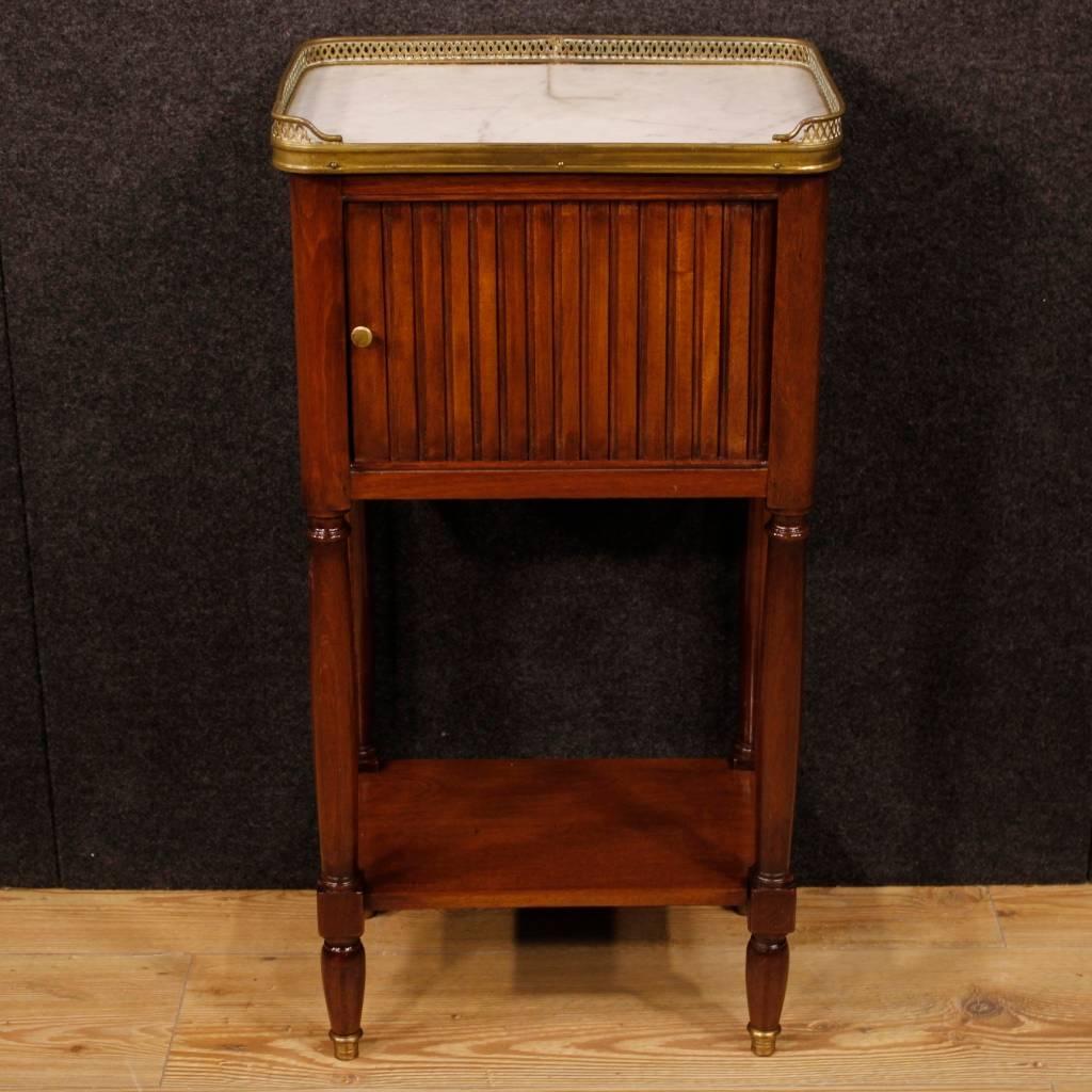 French nightstand of the early 20th century. Furniture in carved mahogany of beautiful line. Bedside table with sliding door of discreet service. Top in original marble decorated with golden brass ring. Bedside table with two shelves of good