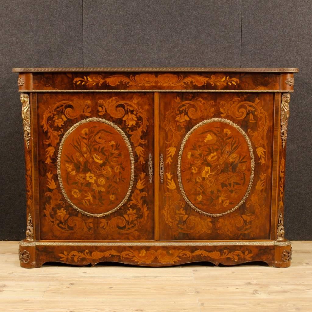 French sideboard of the 20th century. Furniture richly decorated with floral inlay in various precious woods and adorned with bronze and chiselled brass. Two-doors sideboard of good capacity and service, top in character. Furniture of excellent