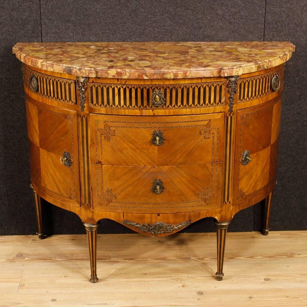 French demilune dresser of the late 19th century. Furniture in Louis XVI style characterized by a pleasant geometric inlay made of rosewood, mahogany, maple, fruitwood and ebonized wood. Chest of drawers with three central drawers, two pull-out
