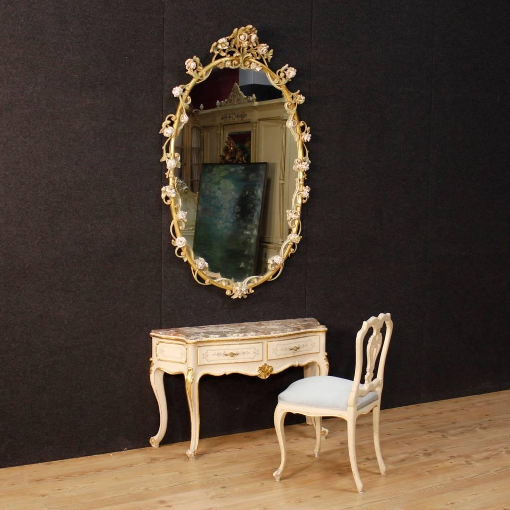 Great Italian mirror of the mid-20th century. Carved, lacquered and golden furniture with floral motifs of fabulous decoration. Mirror of large size and impact, ideal to match with a console. Mirror that is part of a complete furniture coming from