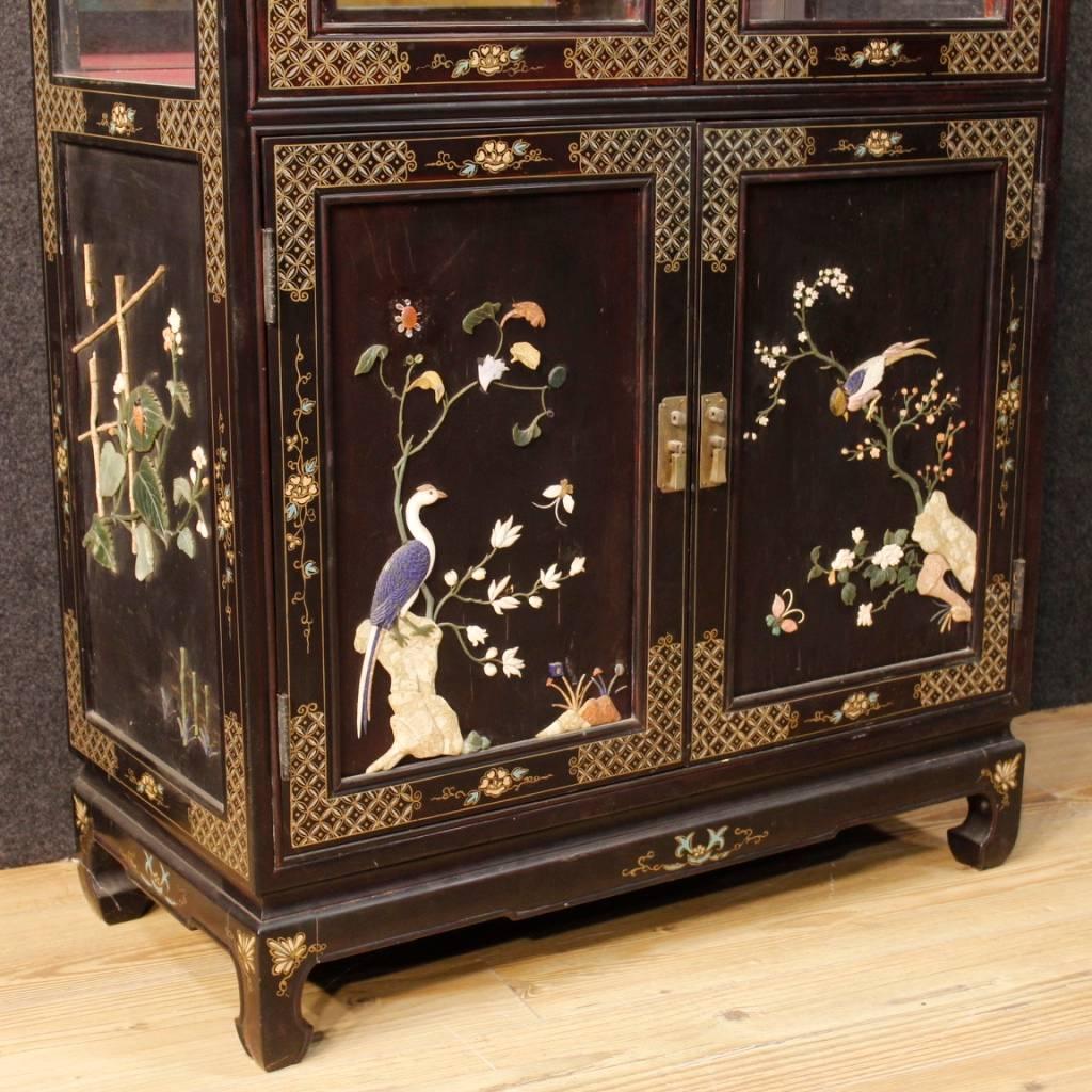 French display cabinet of the 20th century. Chinoiserie furniture in lacquered and painted wood decorated with embellished ornaments. Bookcase built in one body, with two upper doors with built-in glasses and two smaller lower doors. Furniture open