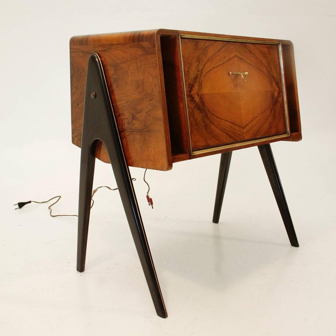 This cabinet with an inbuilt turntable was produced in Italy during the 1940s. The cabinet is made from lacquered wood with a rosewood veneer, and features two legs which are fixed laterally in the shape of an inverted V with a brass insert. A