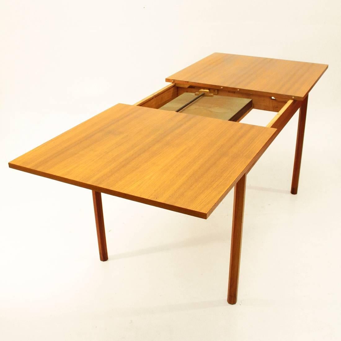 This wooden dining table was manufactured in the 1960s in a Scandinavian style. It has a rectangular shape and the top can be extended with rosewood veneered leaves. The table also features octagonal legs. In a very good vintage condition with a