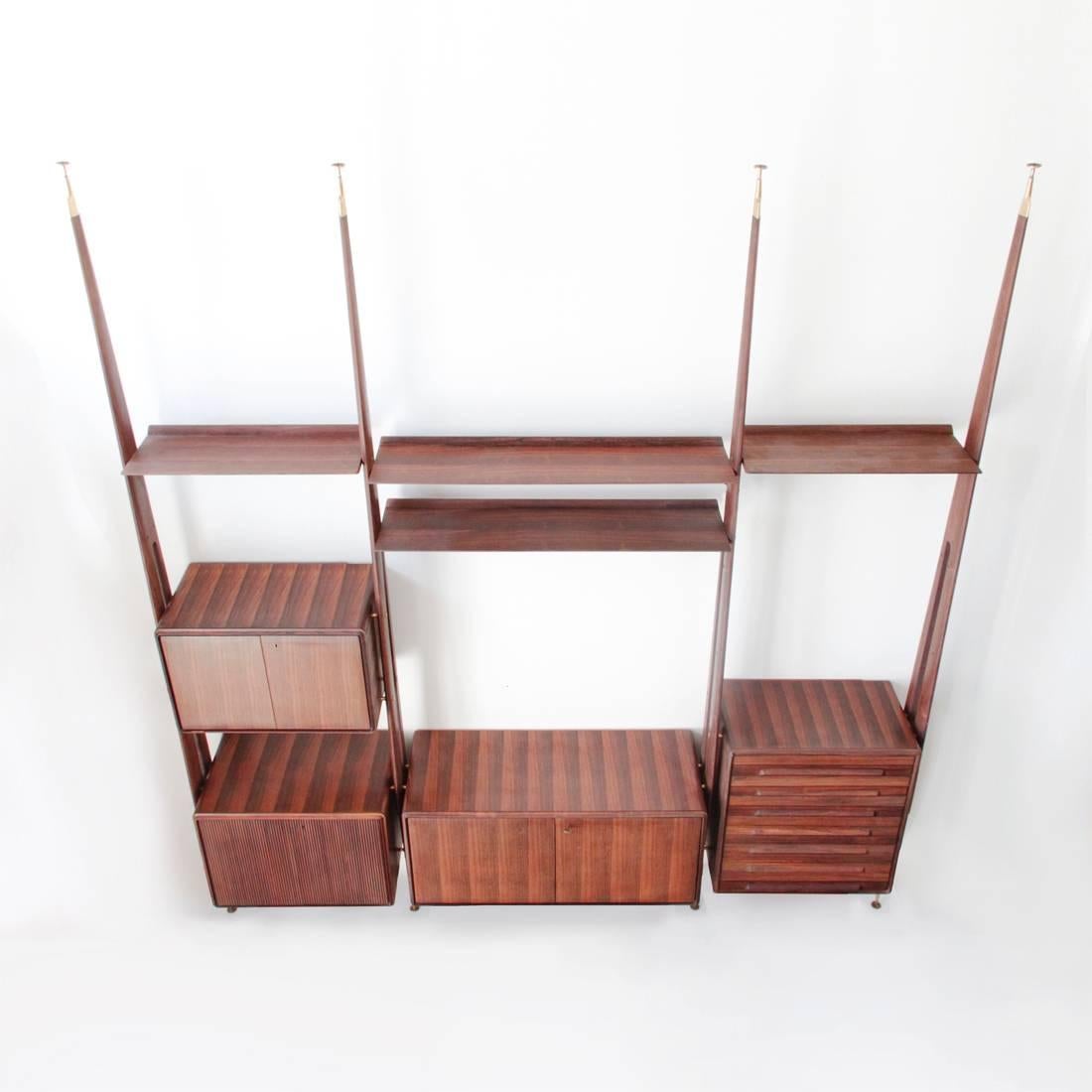 This rosewood wall system was produced by Galleria Mobili d'Arte Cantù. The unit is composed of three modules: The left one has two cabinets and a shelf; the central, bigger one features a cupboard with two doors and two shelves; and the last