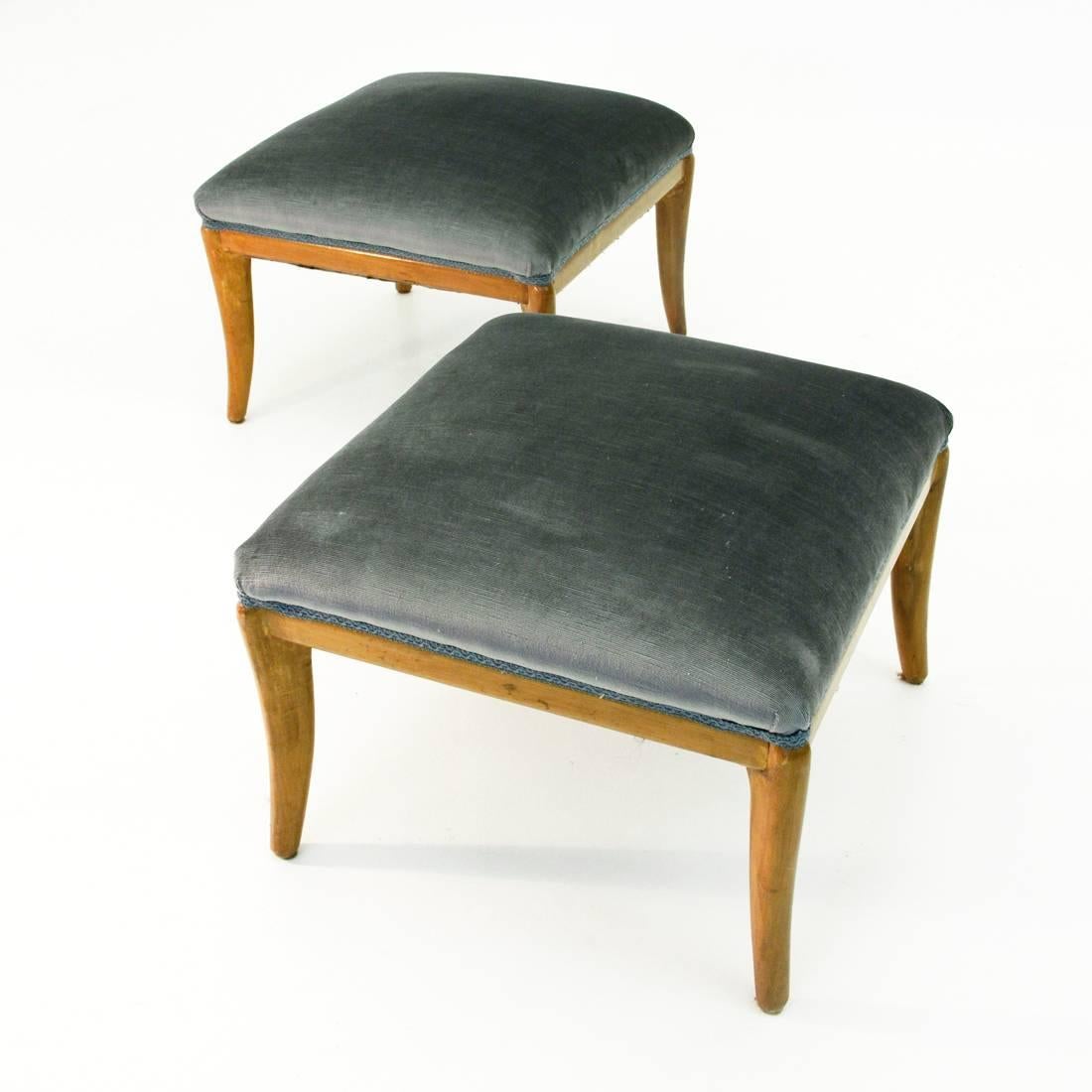This pair of footstools or poufs was produced in Italy in the 1950s. They are made from square wooden bases with curved wooden legs. The seats have been reupholstered in grey velvet.