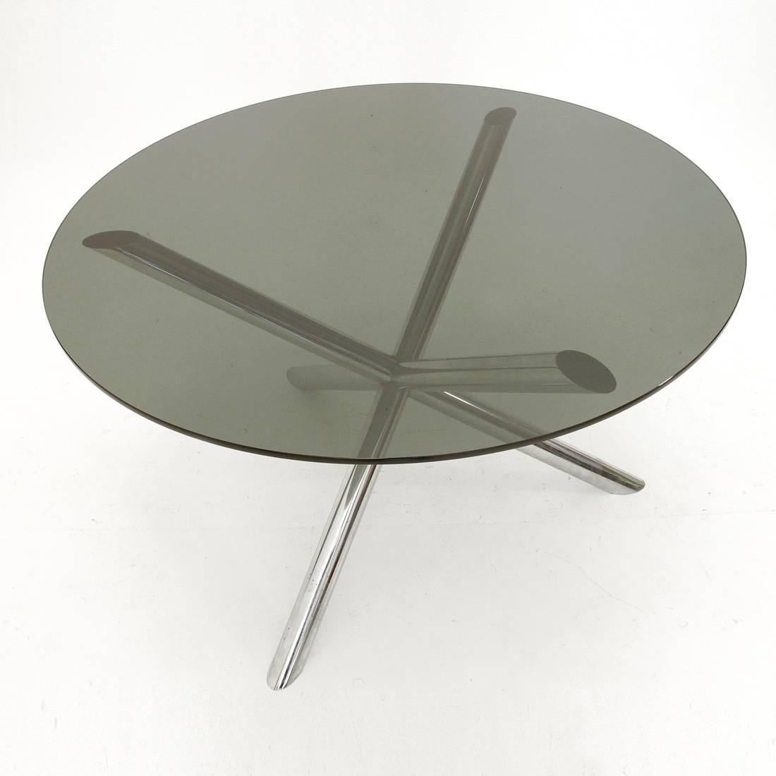 This dining table was produced in France in the 1970s. It has a chromed metal base, three chromed tubular steel bars, with a smoked glass round tabletop.