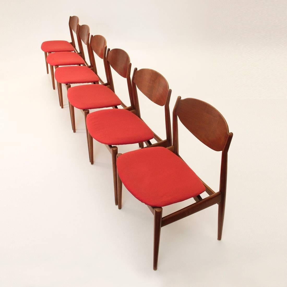 This set of six chairs were produced by ISA Bergamo in the 1960s. Each chair has a wooden frame with curved backs and a red upholstered seat with removable and washable lining. The chairs are in good vintage condition, with some wear on the wood.