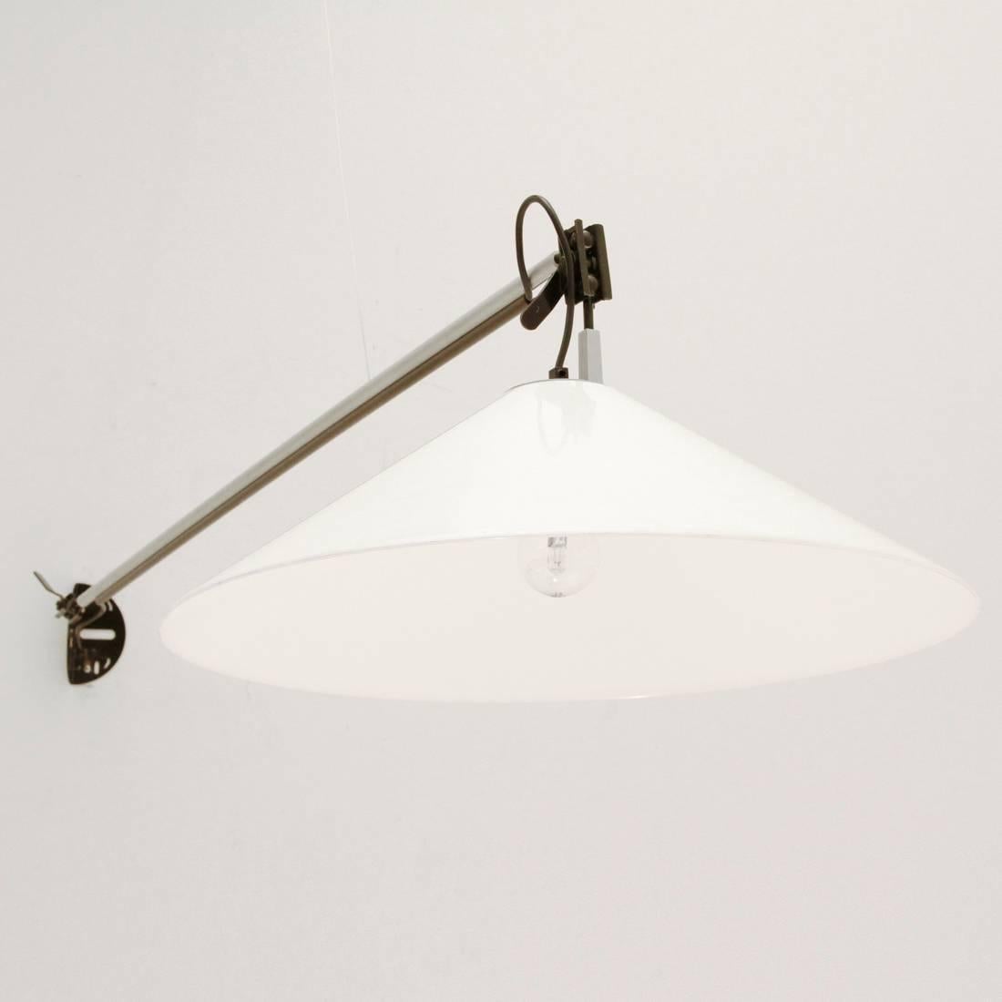 This light was designed in 1974 by Enzo Mari for Artemide. It is made from black metal and aluminium with a conical diffuser in white methacrylate. It can be mounted on either the ceiling or a wall.