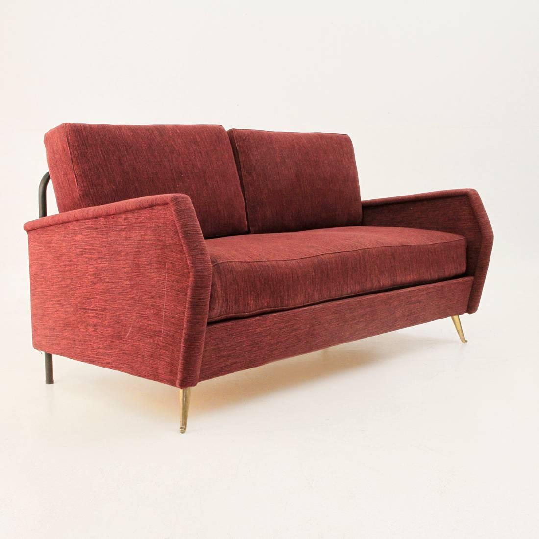 Two seat sofa, Italian 1950s production.
Wooden and metal structure, padded and lined with fabric.
Big cushion on the seat and two pillows as backrest.
One side descends and allows it to become bed.
Front legs in cast brass.
Good general