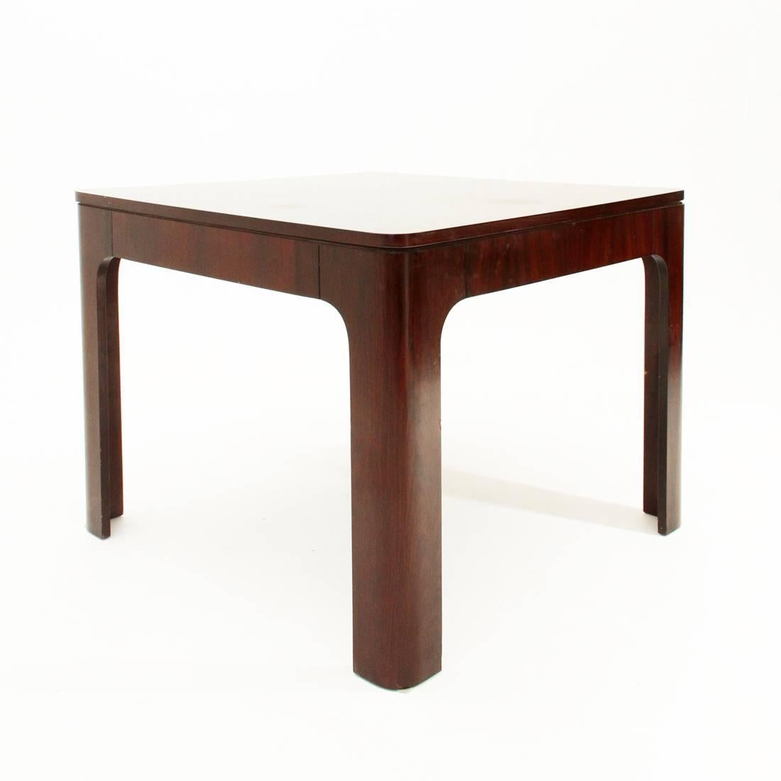 Italian manufacturing table from the 1960s.
Wooden structure in rosewood.
Square plan with rounded edges legs following the floor line.
The plan can be stretched by the presence of an extension, underneath.
Good general conditions, normal usage