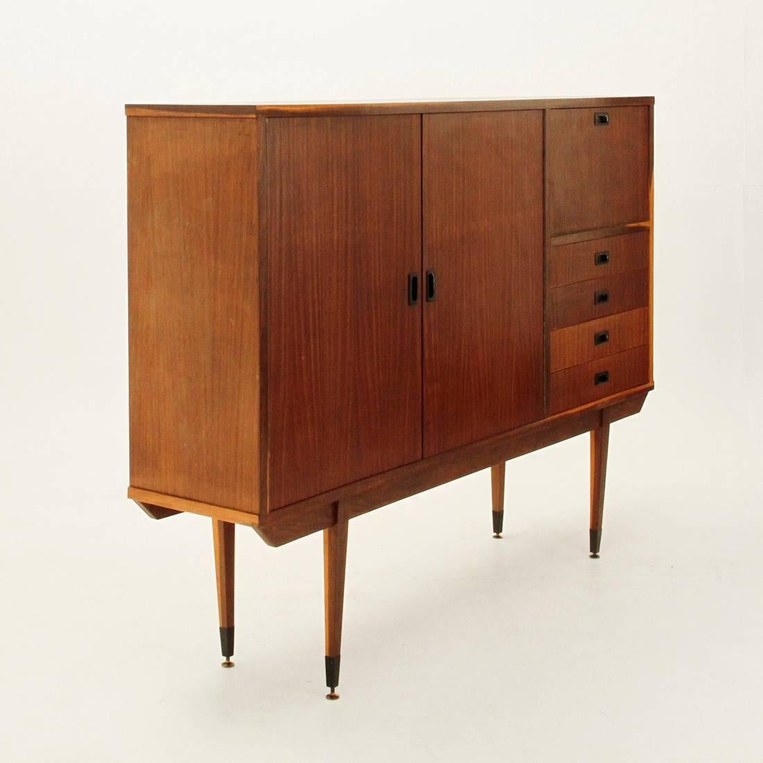 Handmade credenza from the 1950s
Veneered wood structure
One large compartment enclosed by doors
A curved rib and a set of four drawers
Adjustable brass feet
Black lacquered iron handles
Good general conditions.