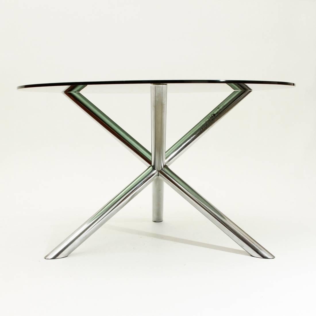 This dining table was produced in France in the 1970s. It has a chromed metal base, which includes three chromed tubular steel bars that supports a smoked glass round tabletop.