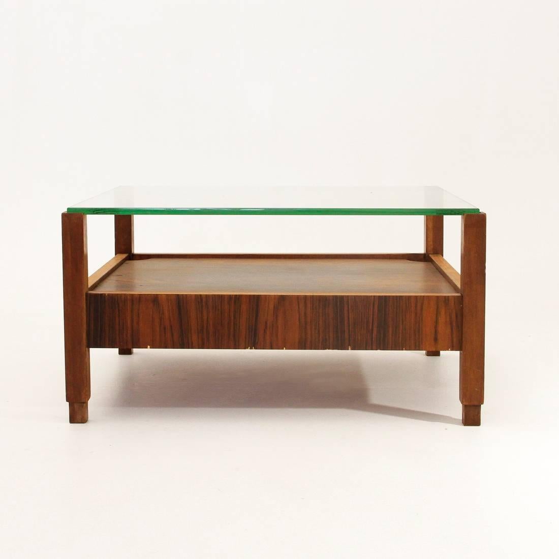Italian coffee table from the 1960s.
Solid wood legs, bottom floor and lateral structures, veneered wood.
Top floor in thick glass.
Good general condition, some signs and shortcomings of veneer.

Dimensions: Width cm 75 cm, depth 65 cm, height
