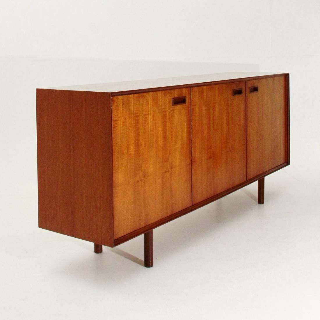 Sideboard of the 1960s in veneered wood.
Frontal frame with grooved groove, three compartments with door opening and internal shelves.
Wooden handle.
Three internal drawers, the first with separators.
Legs in solid cylindrical wood.
Good