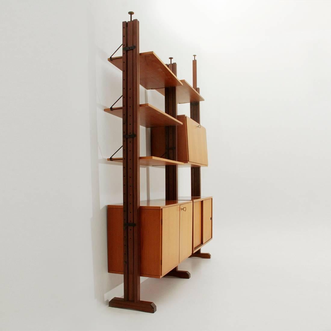 Italian production library of the 1960s.
Adjustable height wooden uprights and brass terminal.
Teak veneered wooden shelves and containers.
Fastening system of shelves in black painted metal.
Good conditions, uprights slightly discolored by