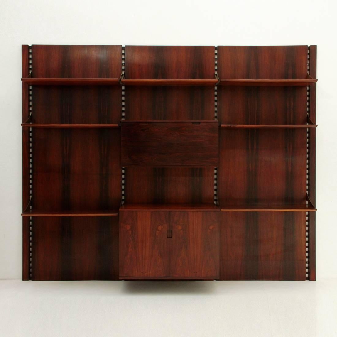 Library produced by Mobilia in the 1960s.
Black varnished iron stands, back panels and storage systems in rosewood veneered wood, burnished brass anchor hooks and embossed handles.
Seven shelves with tapered edges, a compartment with door opening,