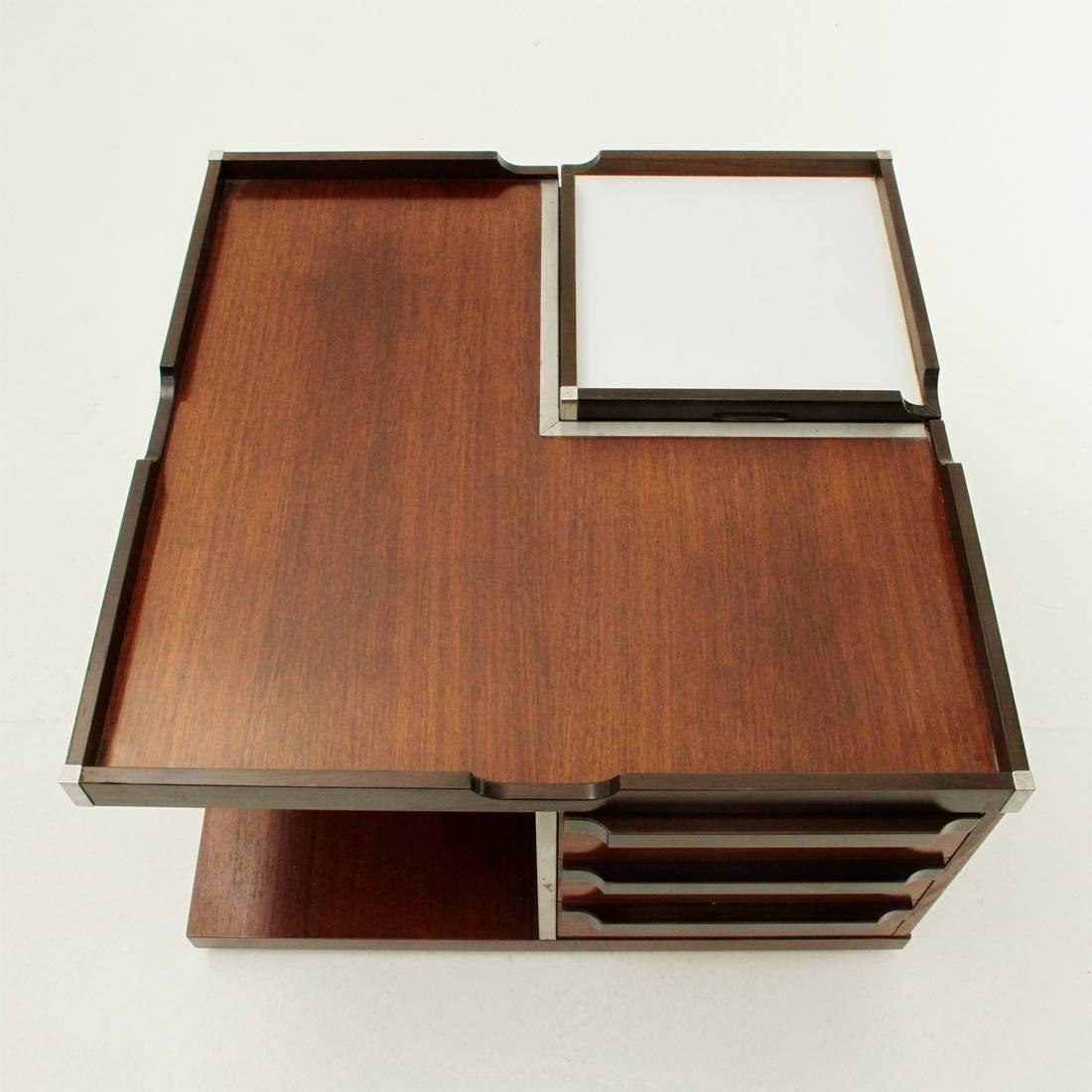 Coffee table produced by Fiarm in the 1970s.
Square table with four compartments:
One open
One closed
One with drawers,
One with upper opening for bottles. Useable cover as a tray.
Metal corners.
Good general conditions, some signs due to