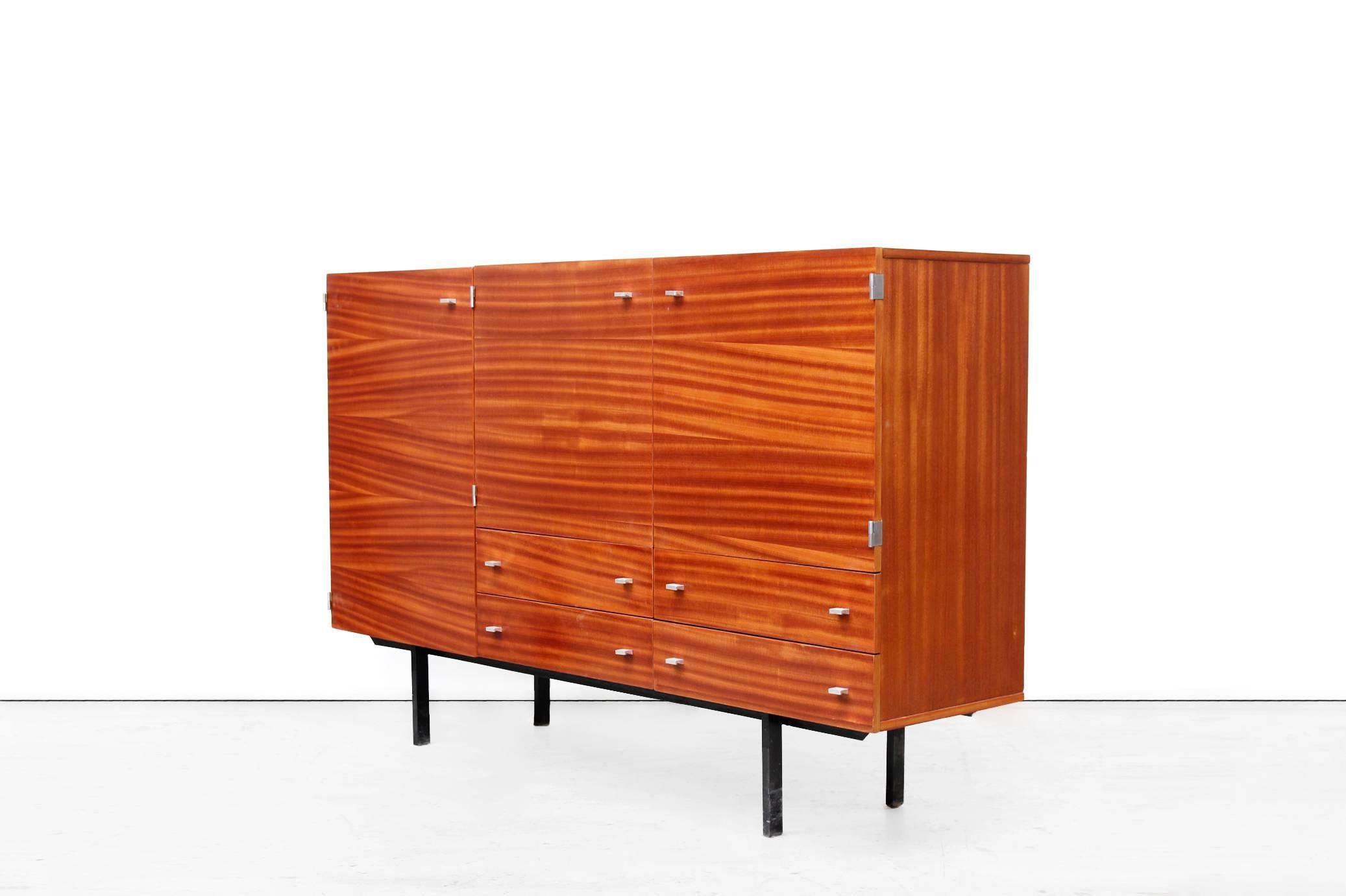 Beautiful credenza designed by Pierre Guariche for Meurop. This sleek Minimalist piece of furniture comes from Belgium and is of very good quality. The beautiful drawing in the teak veneered wood has become visible again after restoration.