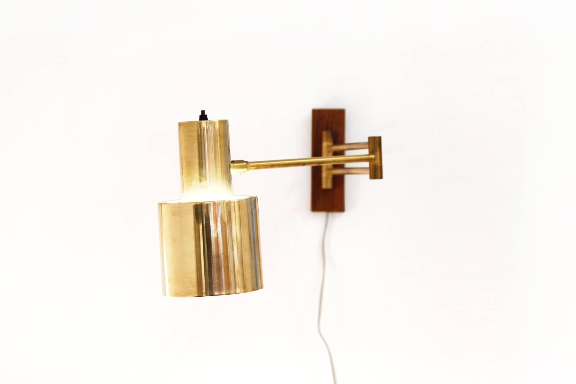 Very nice and complete adjustable wall lamp by Jo Hammerborg for Fog & Mørup, Denmark. It's the model 'Horizont' which is made of solid brass with a brass arm and a teak veneered wall support. The wall mount has a 180 degree turn. The shade itself