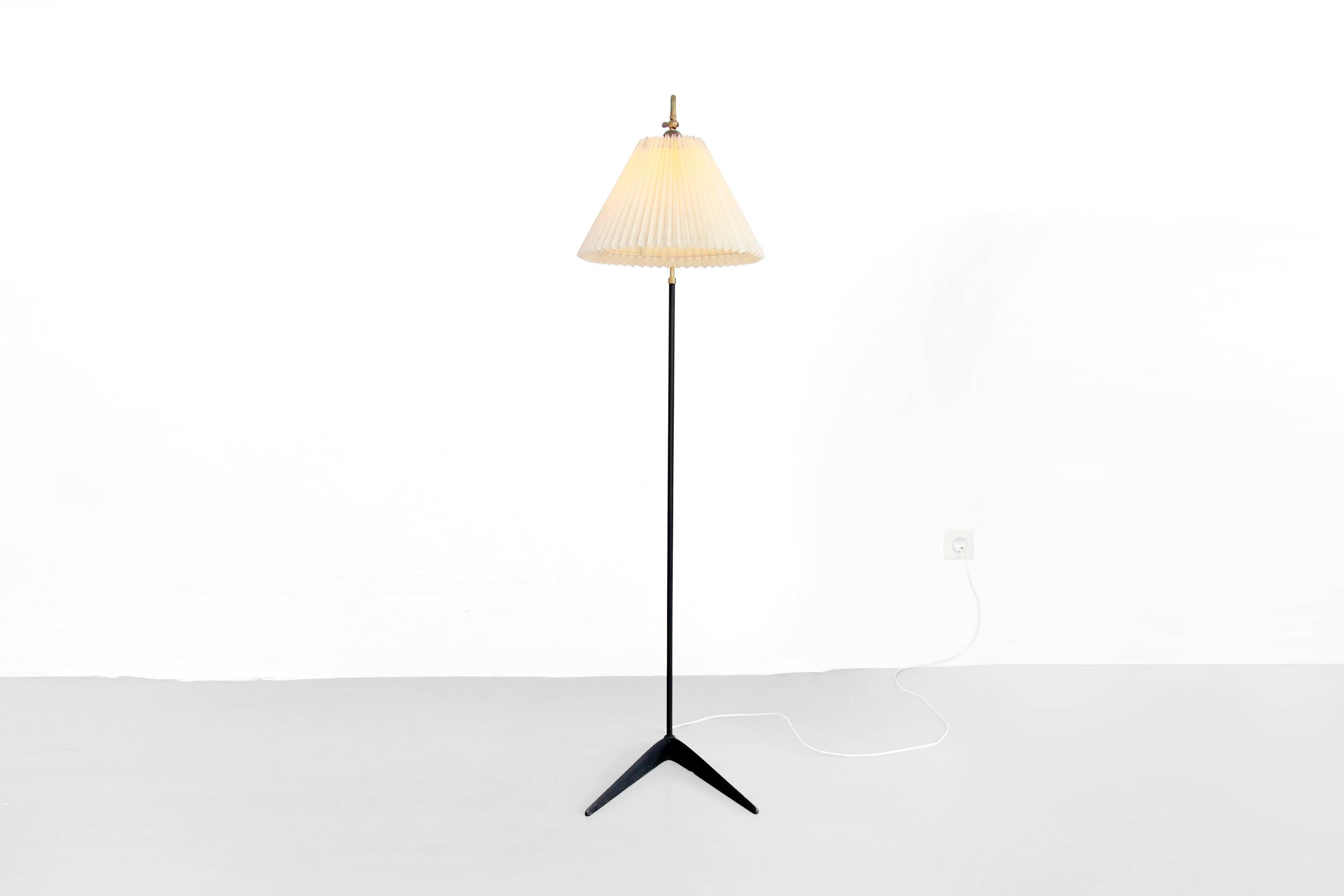 Very beautiful and rare floor lamp designed by Svend Aage Holm Sorensen for Holm Sørensen & Co, Denmark in 1950s. This lamp has a brass and black lacquered stem that rests on a beautifully crafted cast iron base. The lamp shade is also very