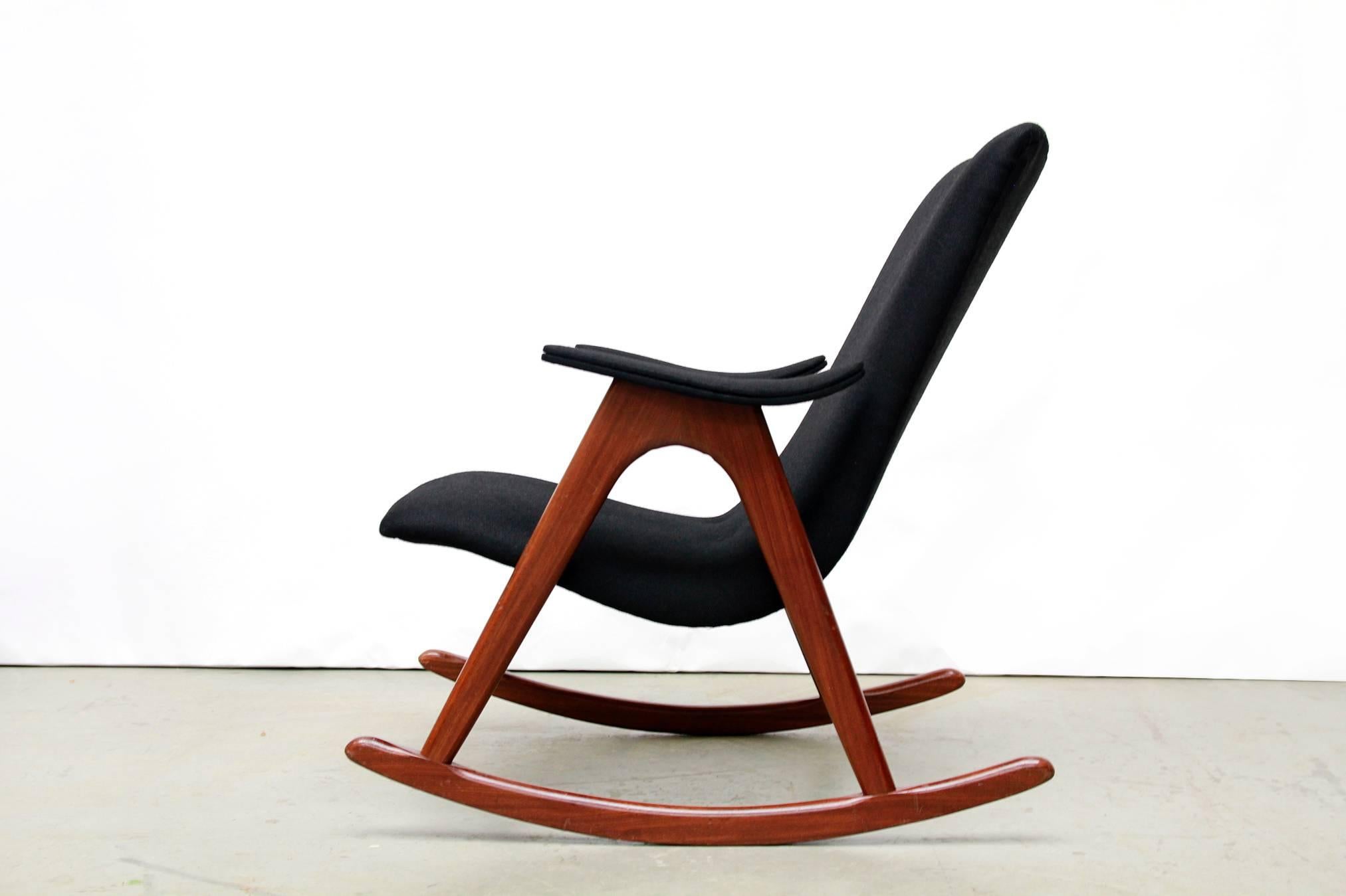 This rocking chair was designed by Louis Van Teeffelen for WéBé in the Netherlands during the 1960s.
This beautiful vintage design armchair is upholstered in a black woolen upholstery.
The frame is made of solid teak and has a swing base.
The