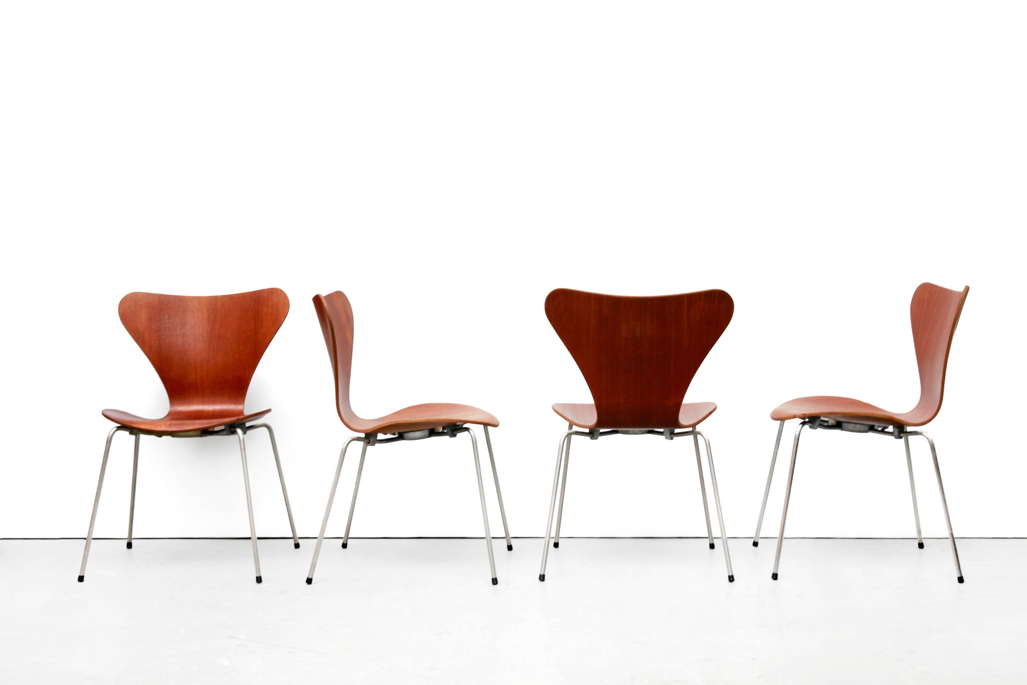 This set was designed by Arne Jacobsen and produced by Fritz Hansen in the 1950s. The teak model 3107 'seven series' butterfly chairs are imprinted by the maker on the metal plate underneath the chairs. These original chairs feature teak plywood