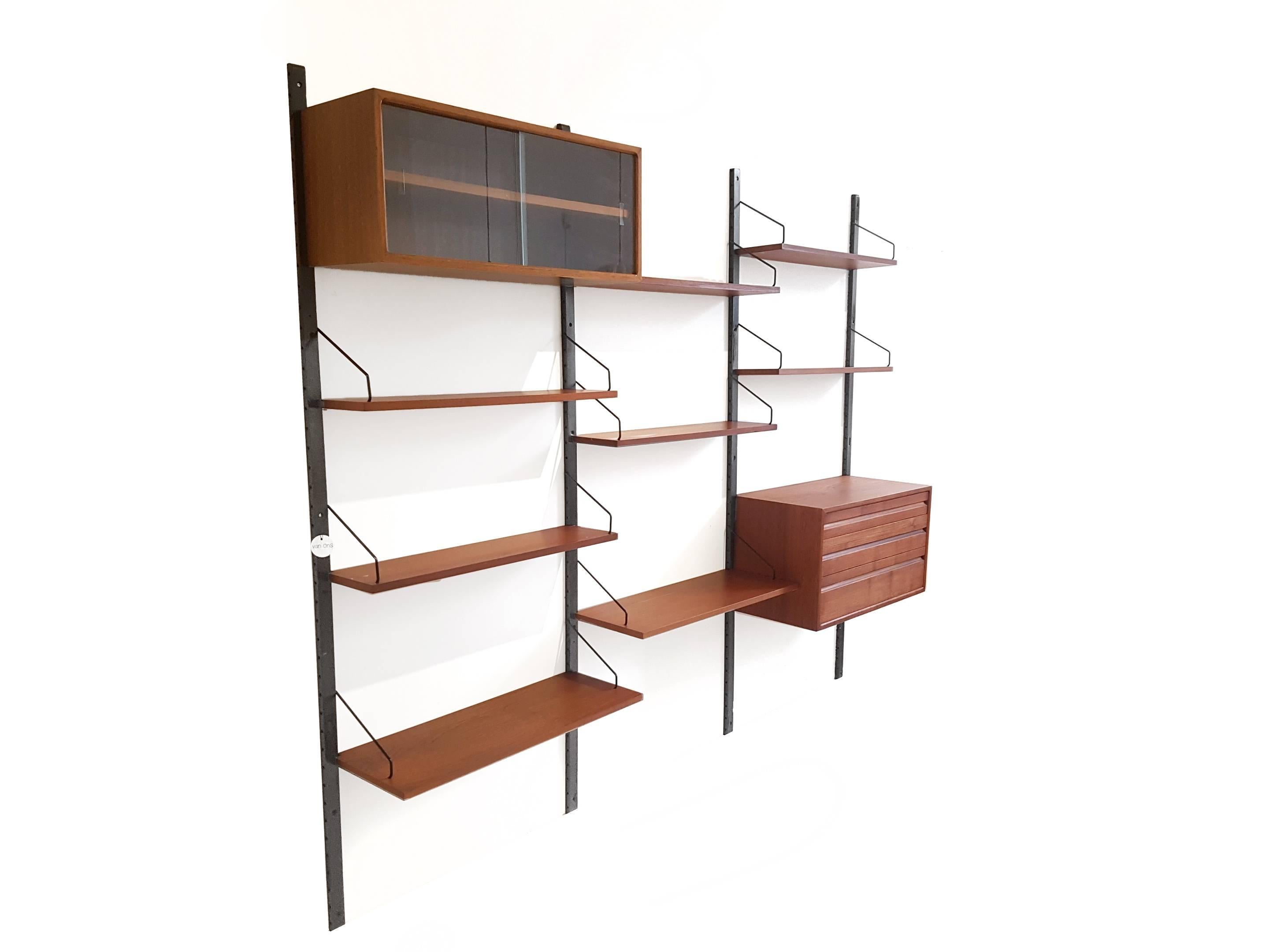 Very beautiful and large wall system made of teak designed by Poul Cadovius and produced by Royal System Denmark. This wall cabinet consists of four wooden stands, eight shelves, and two cabinets. It is not only a beautiful object at home, but also
