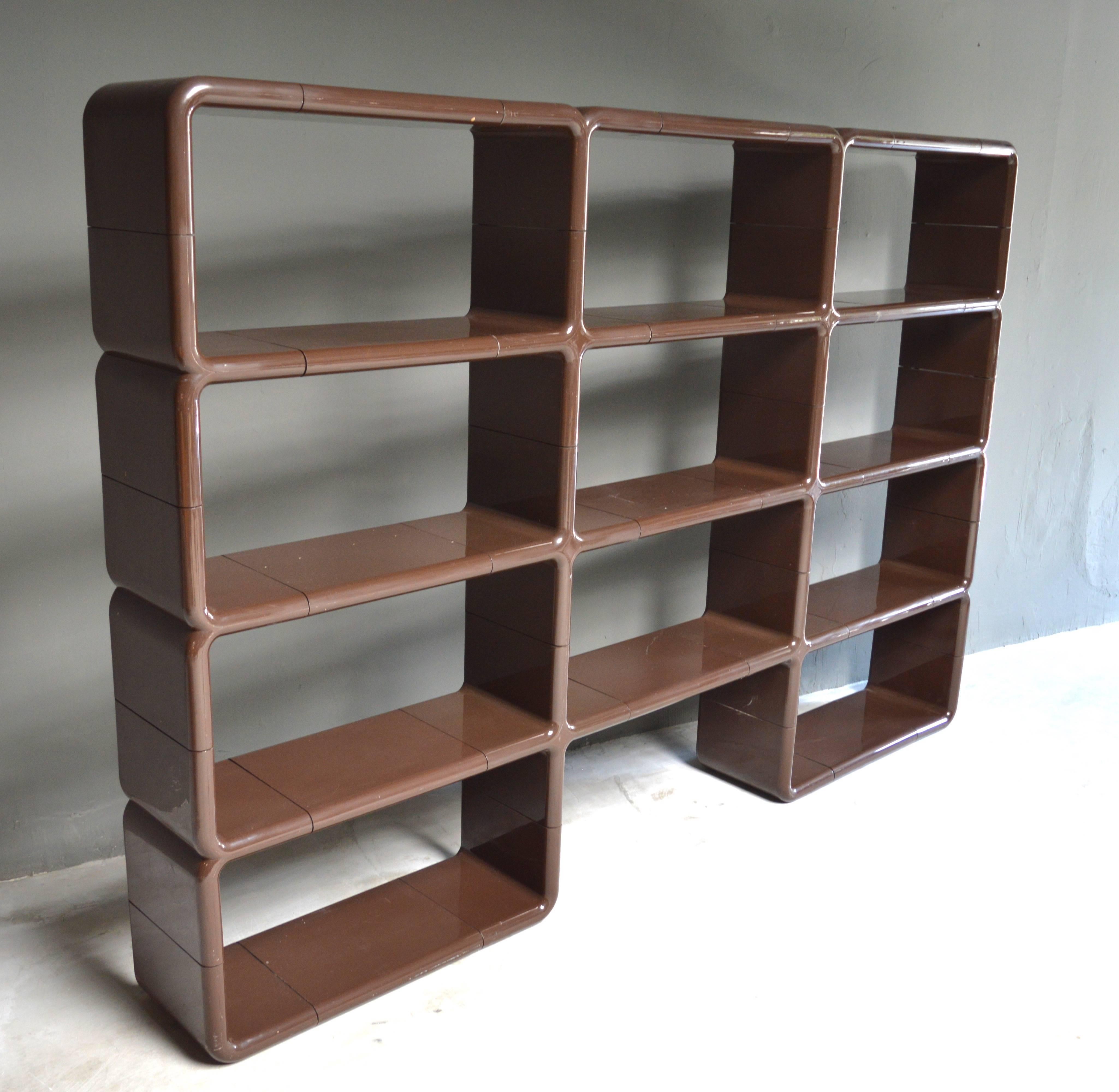 Four-tiered plastic bookcase/shelving unit by Kay Leroy Ruggles. Modular unit includes 34 individual pieces which can be arranged in a multitude of ways. Deep chocolate brown color. Scratches throughout. Some internal pegs missing. Very presentable