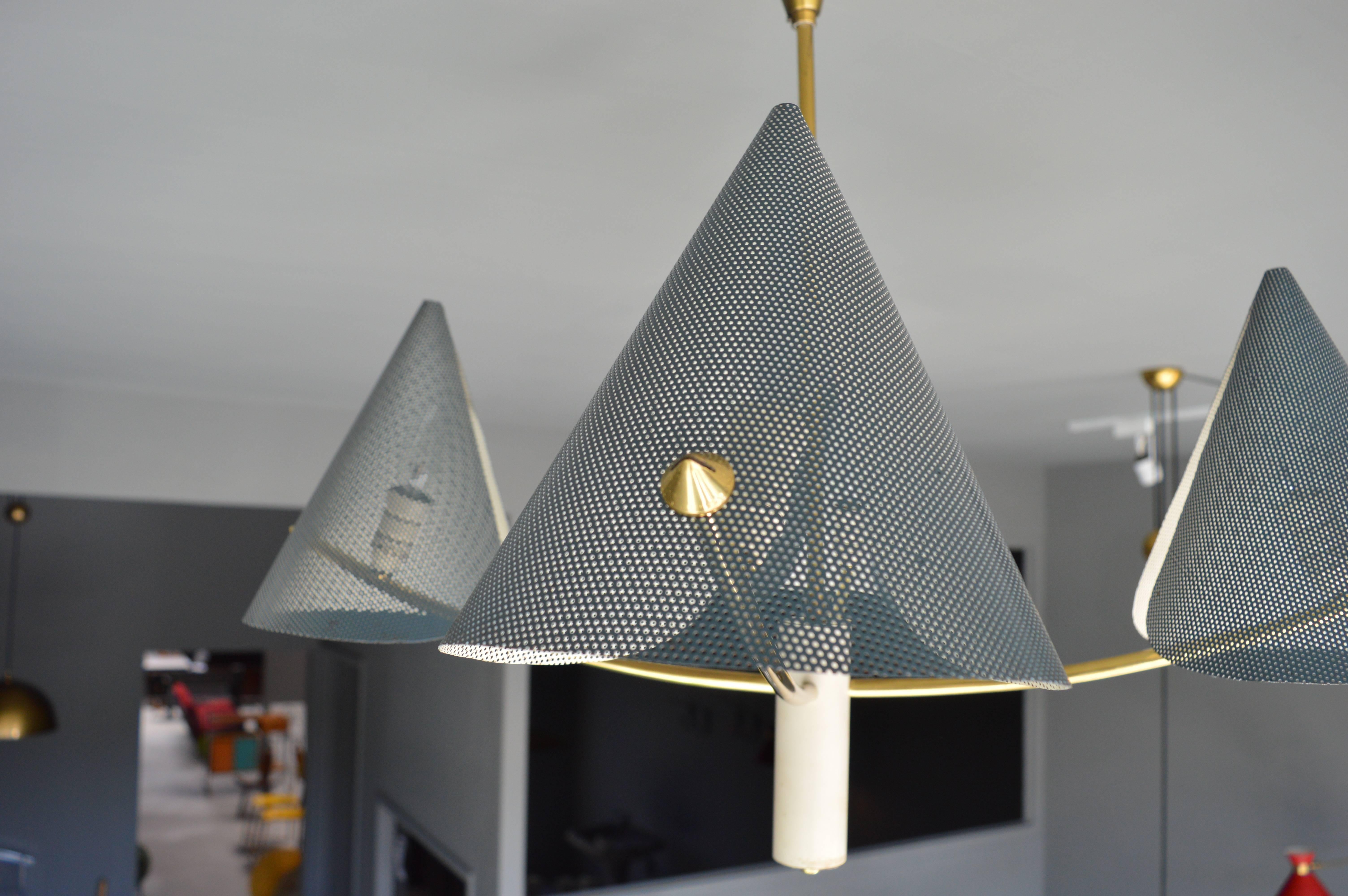 Gorgeous chandelier in the style of French designer Mathieu Matégot. Brass frame and hardware with blue perforated metal cone shades. Excellent vintage condition. Great lines and perfect scale. Chandelier looks amazing both on and off!