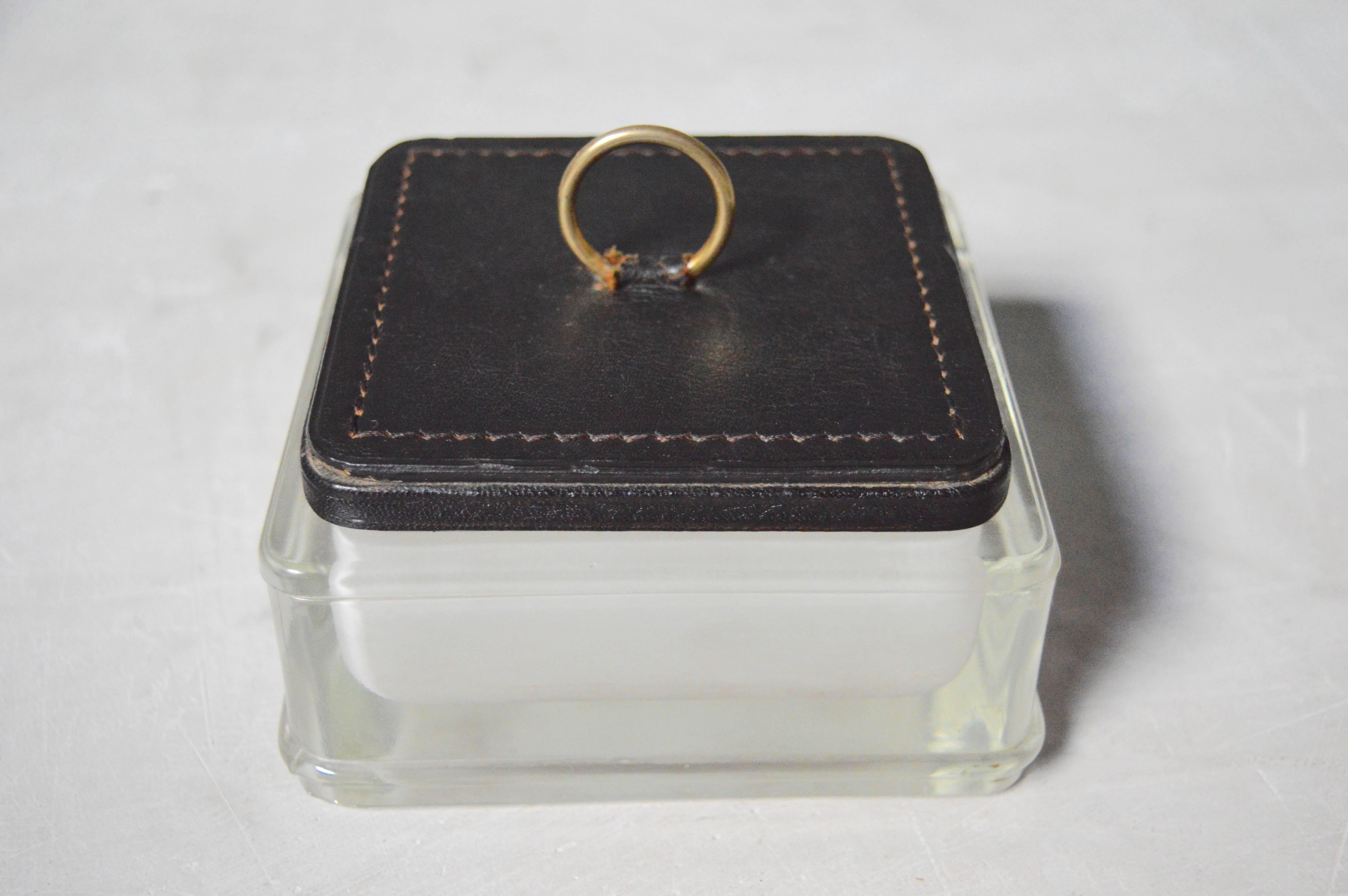 Handsome box/catch-all by French designer Jacques Adnet. Glass tray with removable lid. Black leather has signature contrast stitching and brass hardware. Very unique piece.