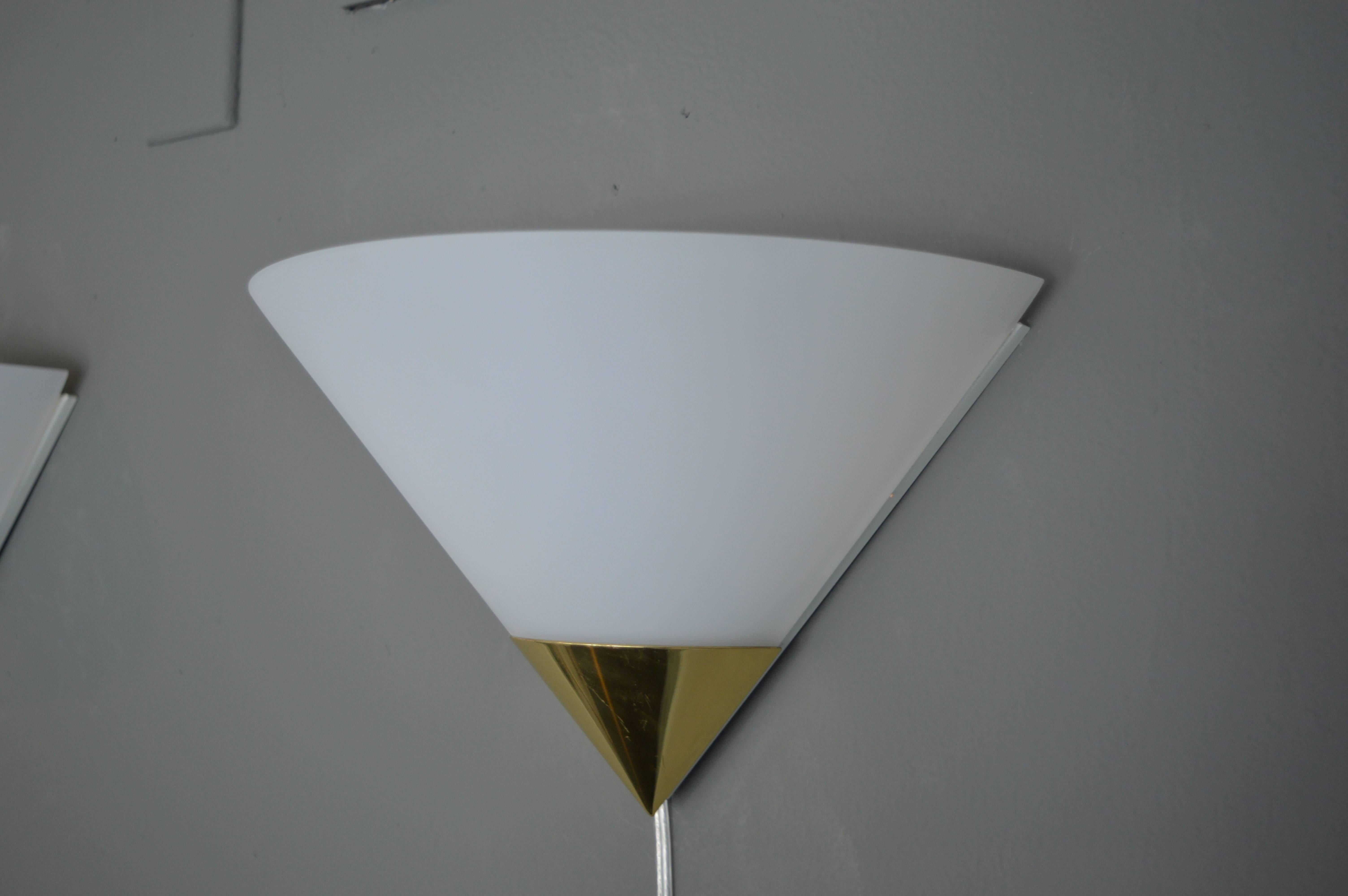 Excellent pair of brass and glass triangular sconces. Powder coated steel frame, brass base and opaque glass shade. Light scratches to brass. Newly rewired. Excellent vintage condition.