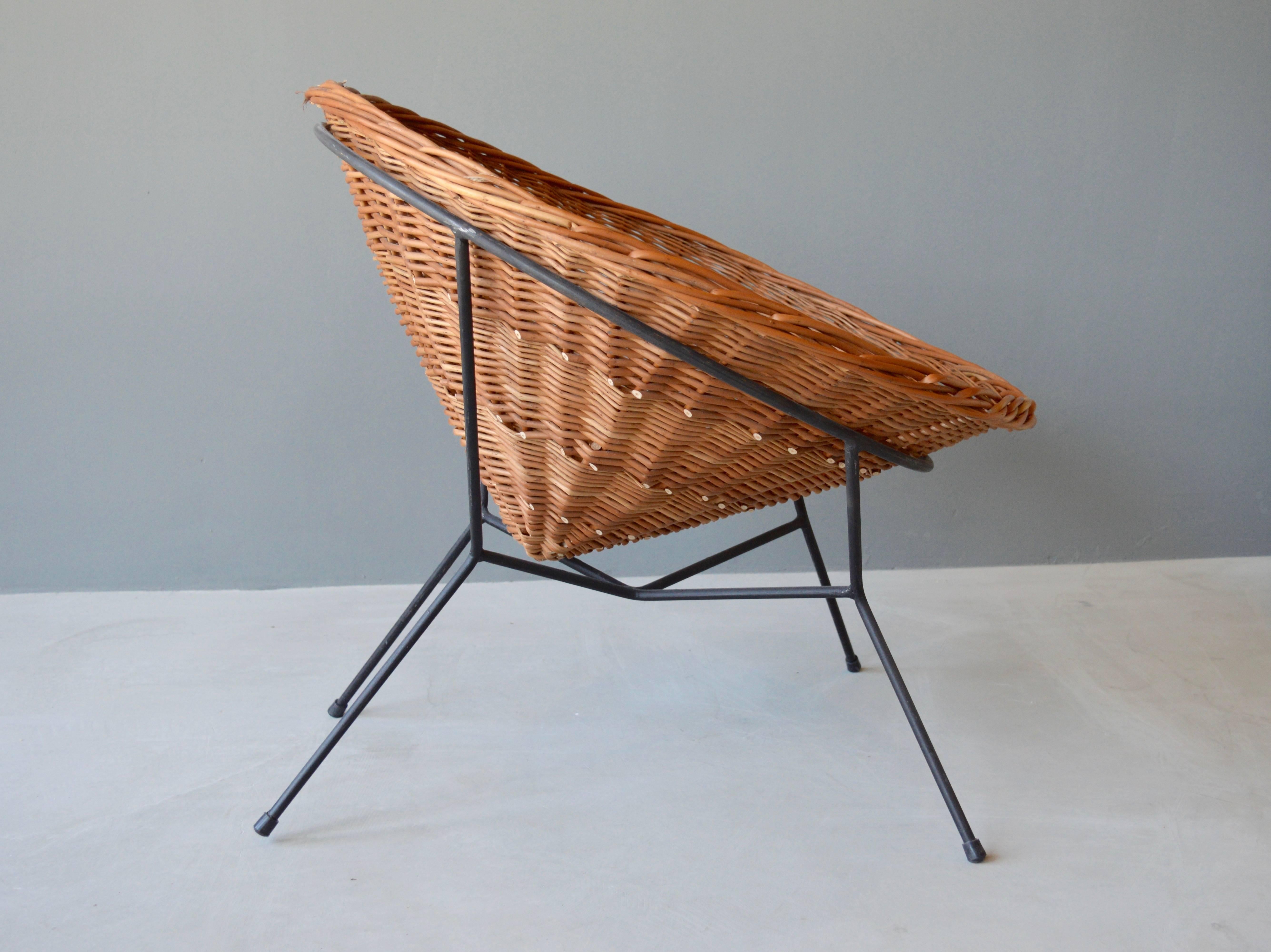 French sculptural rattan and iron chair. Handwoven cone shaped rattan seat sits freely inside the iron frame. One of a kind, prototype chair. Very good vintage condition.