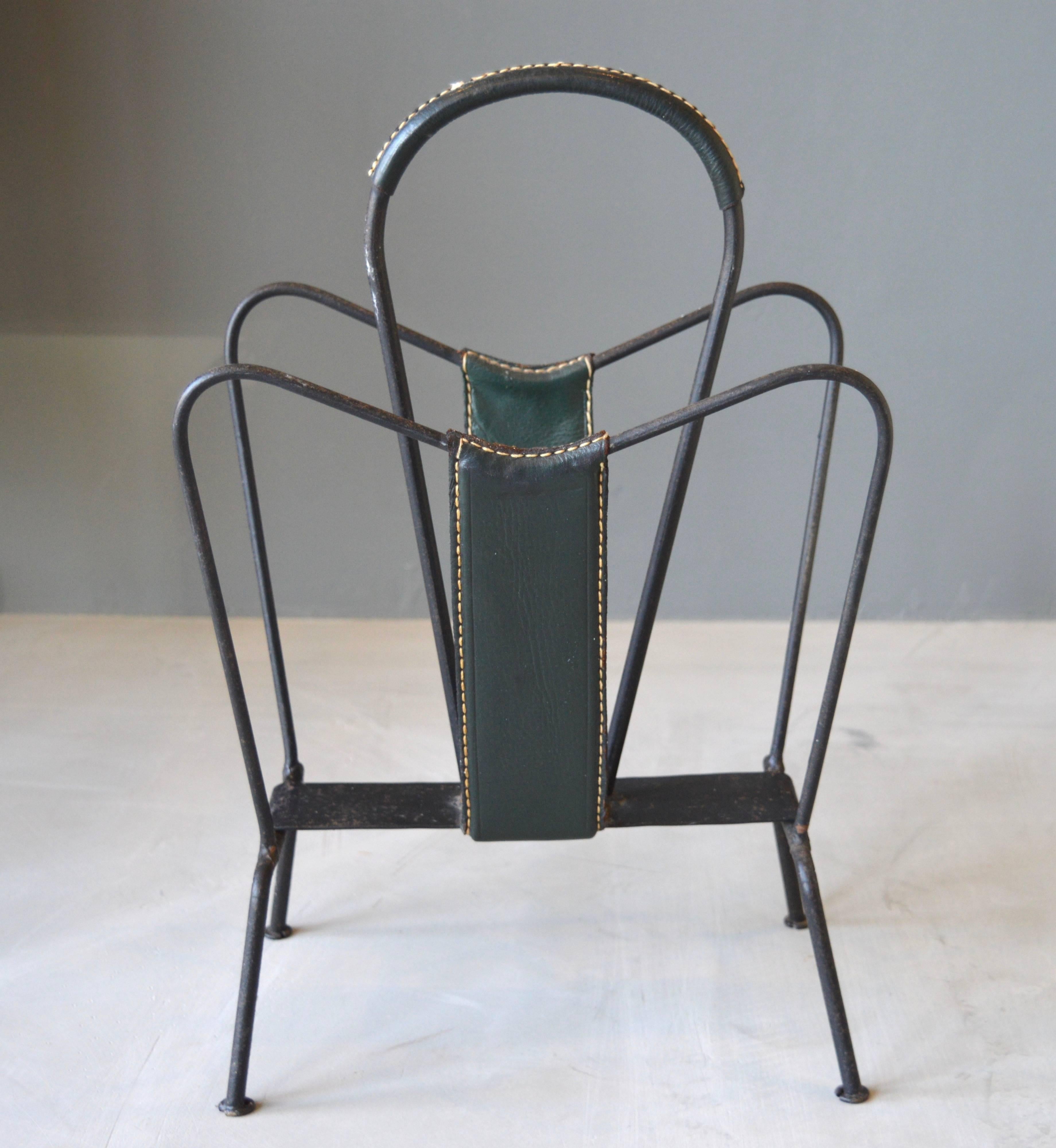 Handsome magazine rack by Jacques Adnet. Iron frame with dark green leather. Signature Adnet contrast stitching. Excellent vintage condition.

Matching magazine rack in yellow leather available in separate listing.