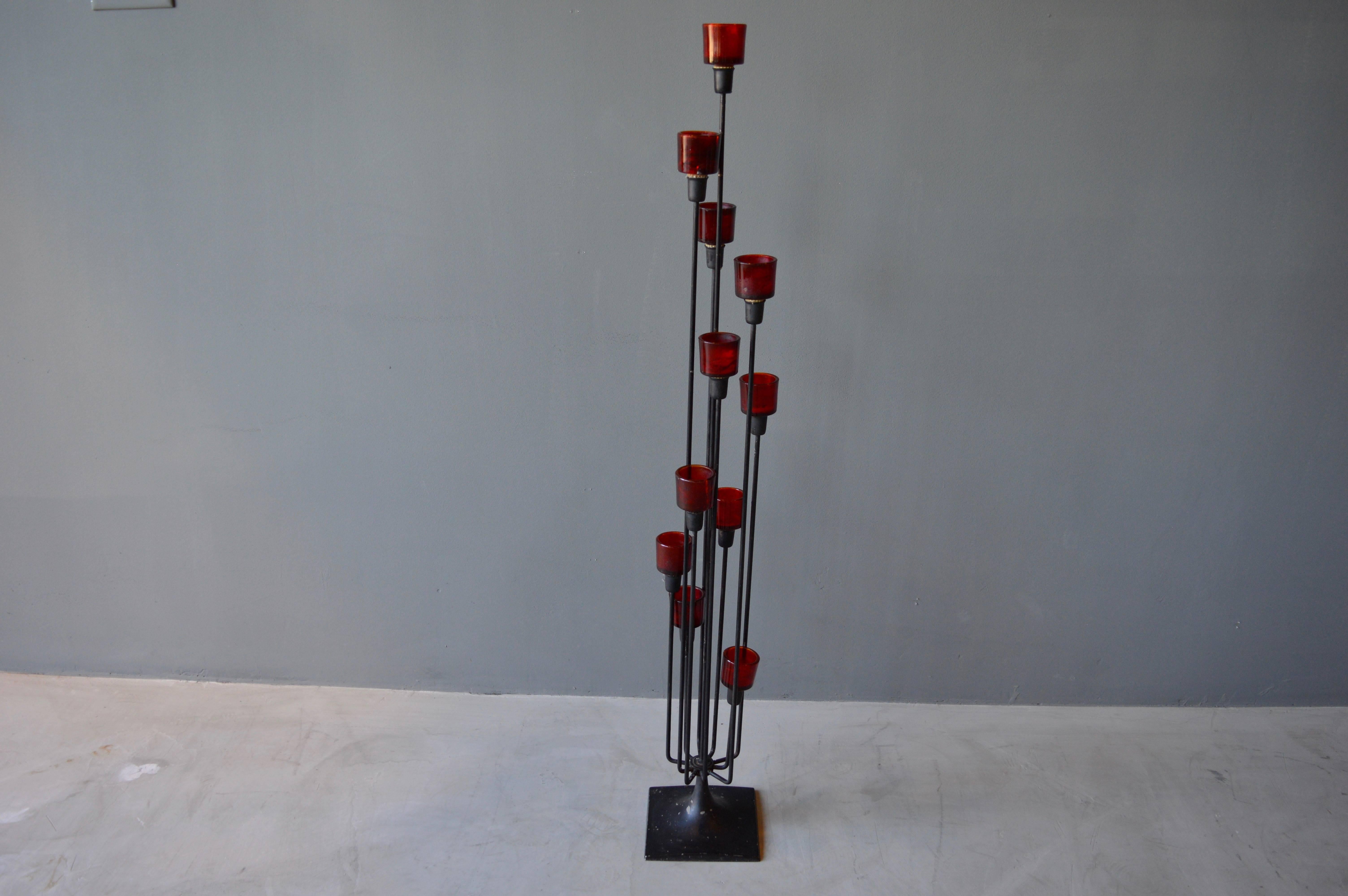 Excellent iron floor candelabra with 11 arms. Red glass candleholders are removable. Great scale. Good vintage condition.