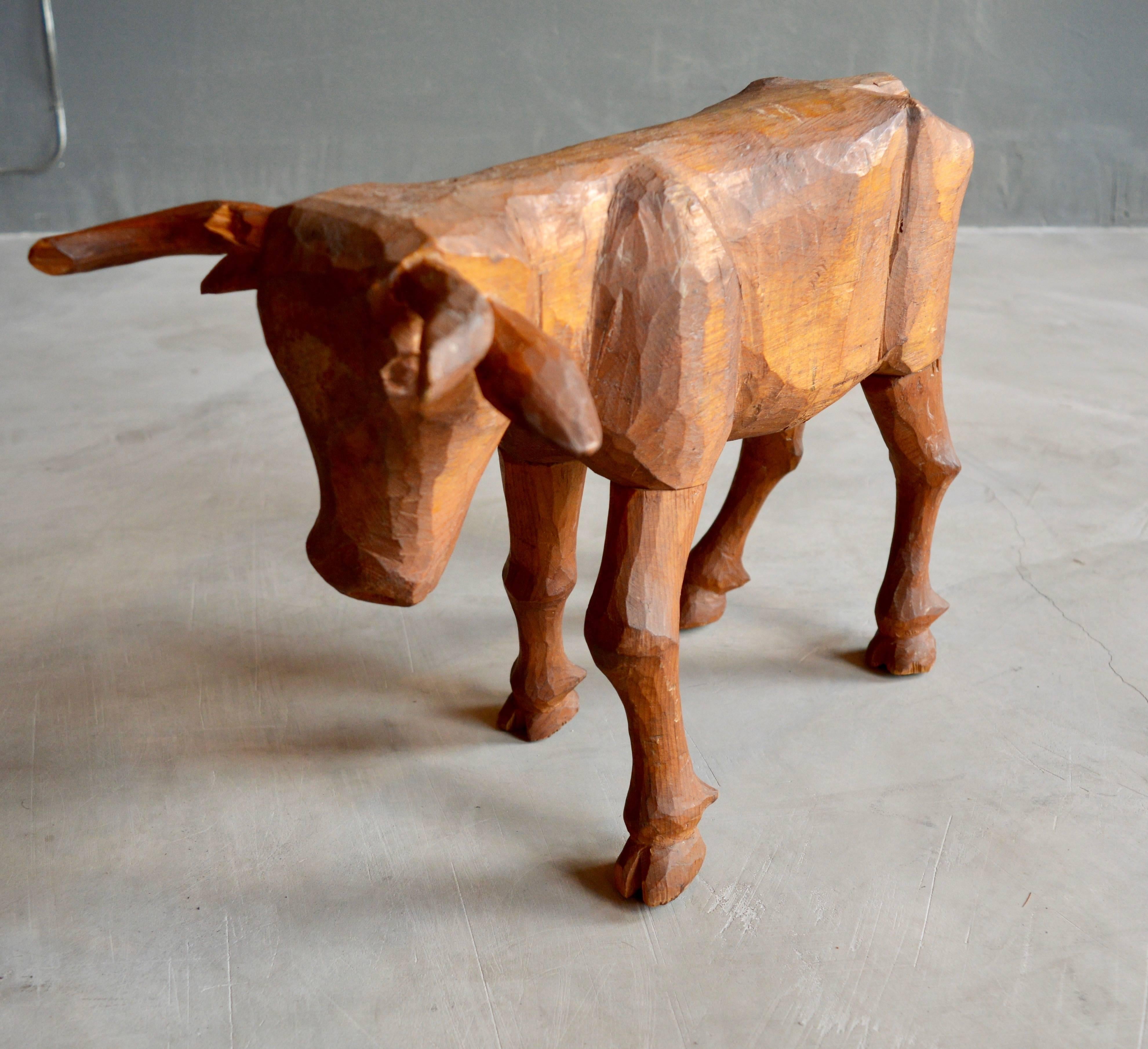Primitive hand-carved Folk Art bull made of wood. Great hand work and scale. One Horn has a chip. Great sculptural piece.