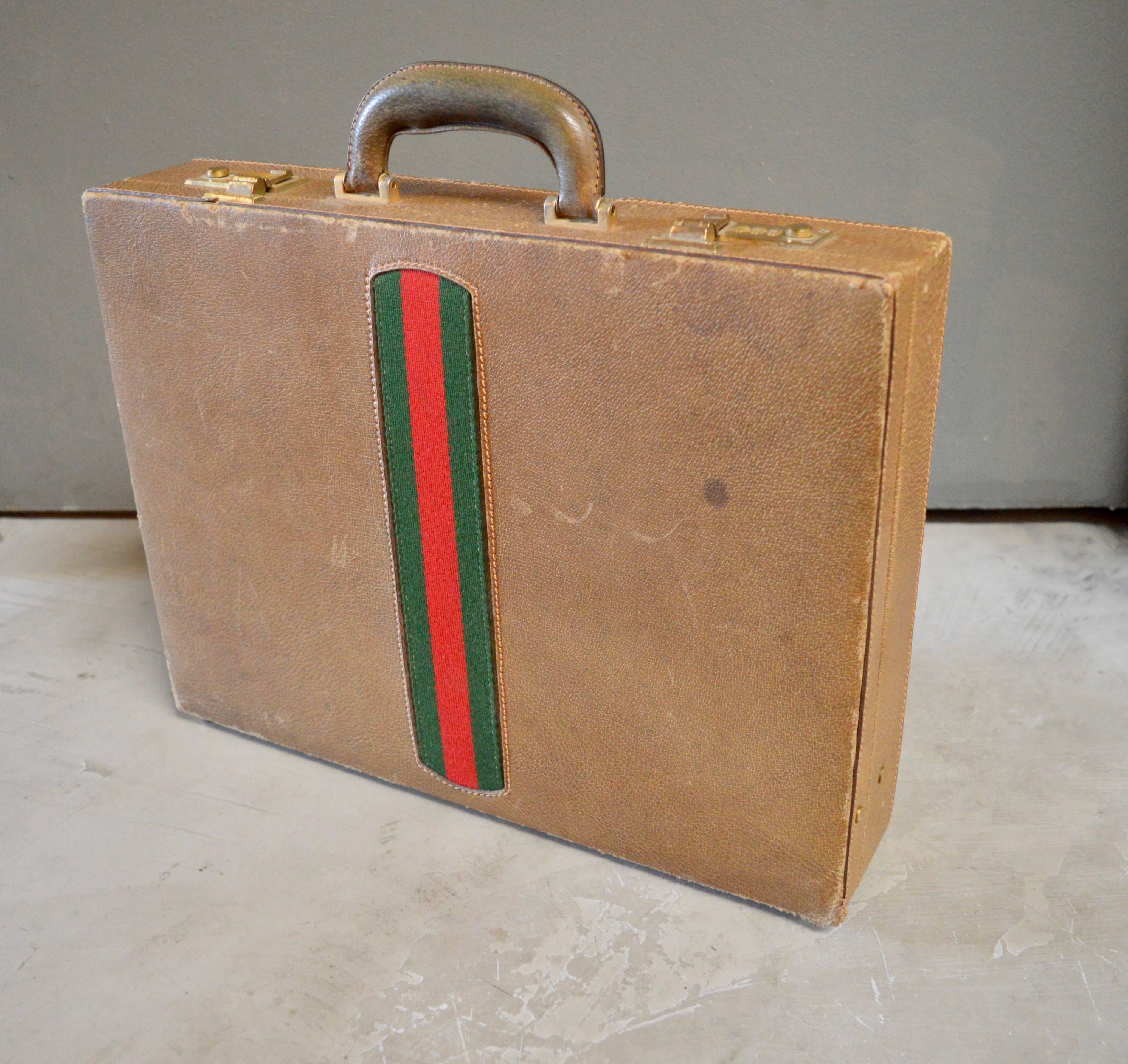 Excellent leather Gucci briefcase with signature Gucci stripes on both sides. Great coloring and patina to leather. Brass closures. Roomy inside with leather sleeves for holding papers. Brass clasps on both sides of leather sleeves allowing to allow