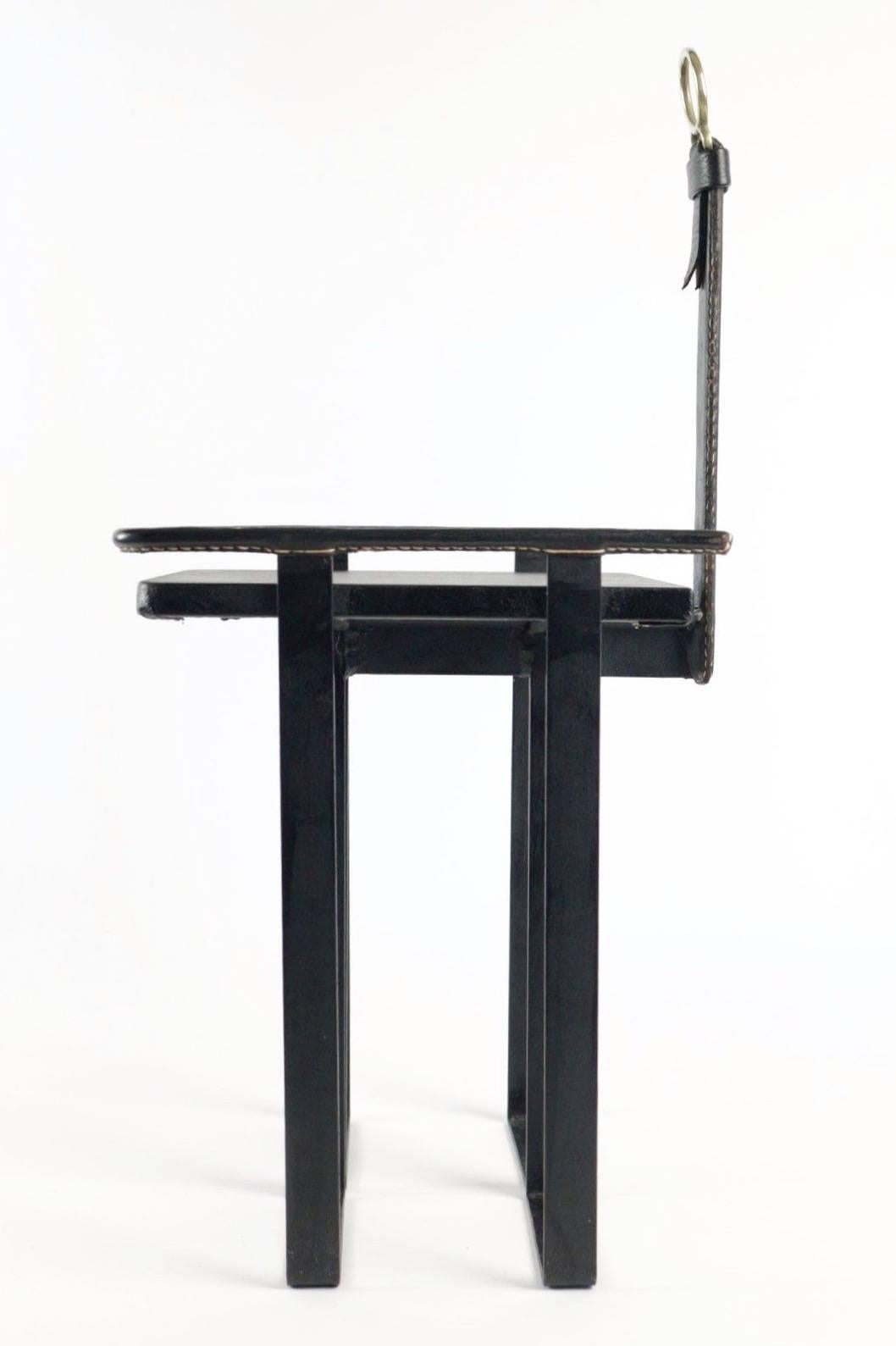Rare leather and iron table by French designer Jacques Adnet. Perfect table for your phone or books. Black leather in excellent vintage condition with characteristic Adnet contrast stitching.