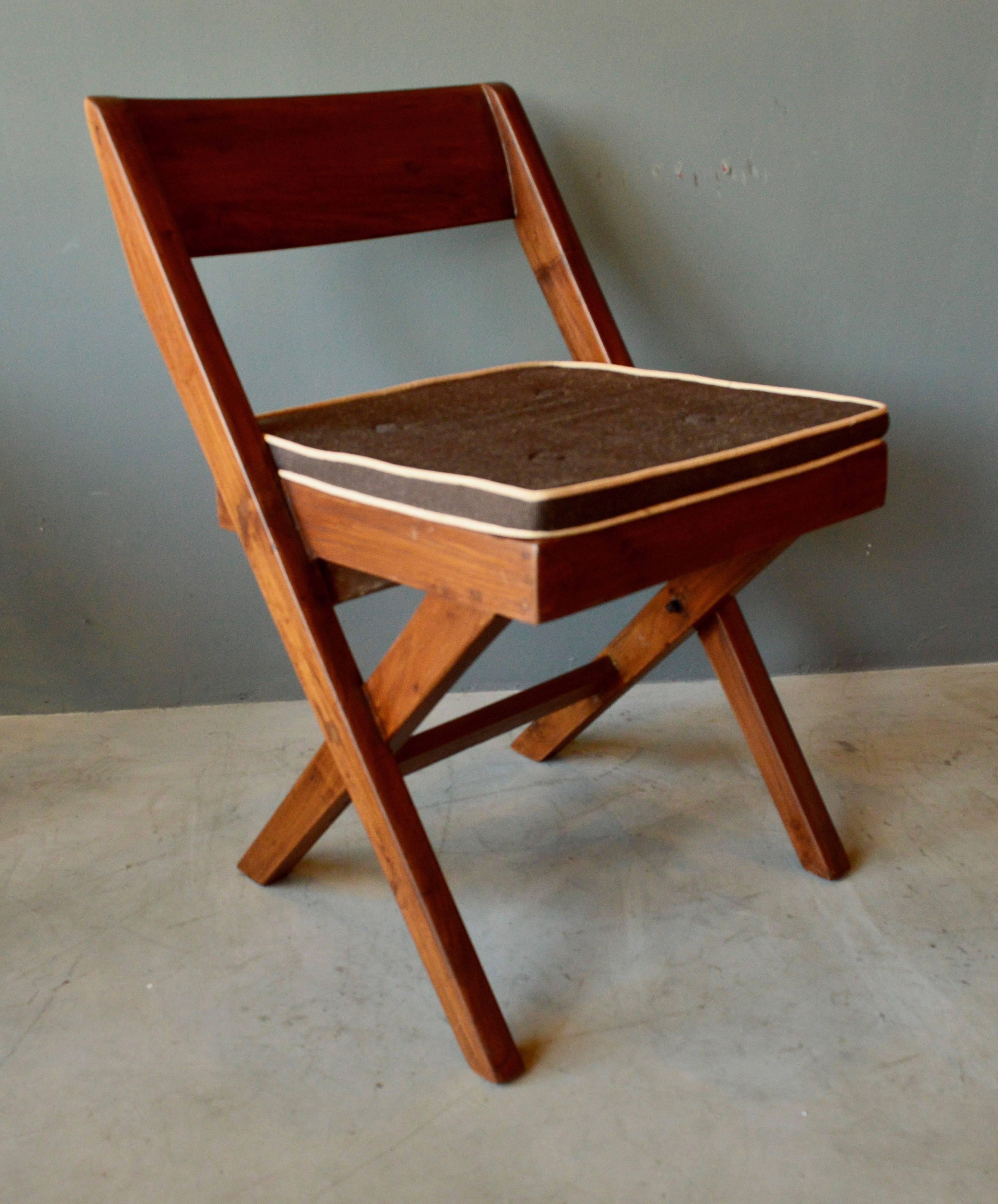 Stunning library chair by Pierre Jeanneret. Made for the Central Library of Punjab University in Chandigarh. Solid teak chair with cane seat and brown cushion. Excellent condition.