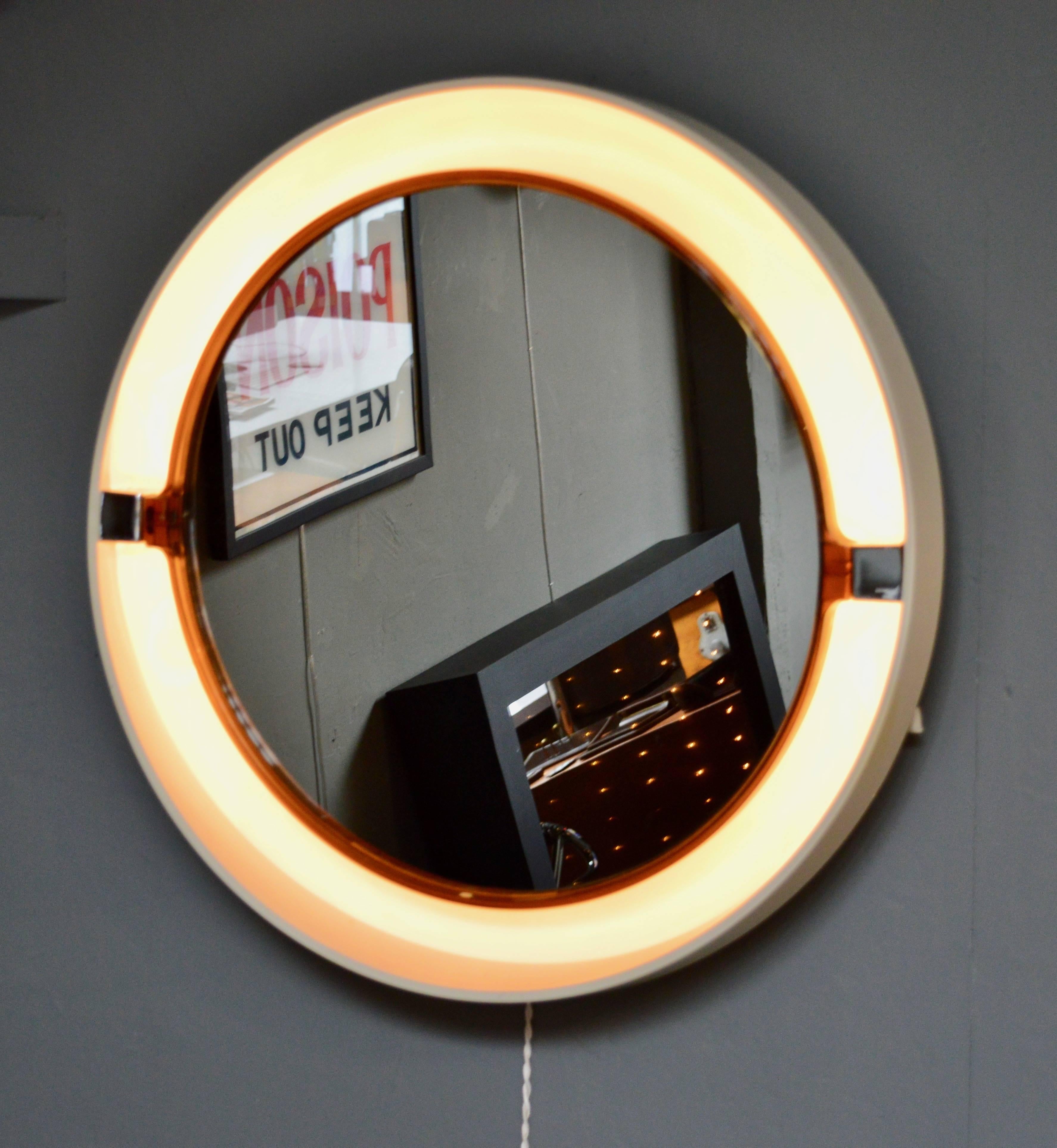 Fantastic vintage plastic and plexiglass adjustable mirror made in Germany. Plastic frame with plexiglass trimmed mirror. Perfect size. Small pull switch on side to turn on and off. Mirror angles up or down. Looks great on and off. Perfect for a
