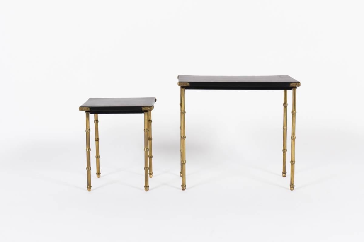 Stunning pair of side tables by Jacques Adnet. Leather tops with brass bamboo legs and brass hardware. In extremely good, original condition. Gorgeous piece of design.

Larger table dimensions - 12.25" D x 20" W x 18.5" H

Smaller