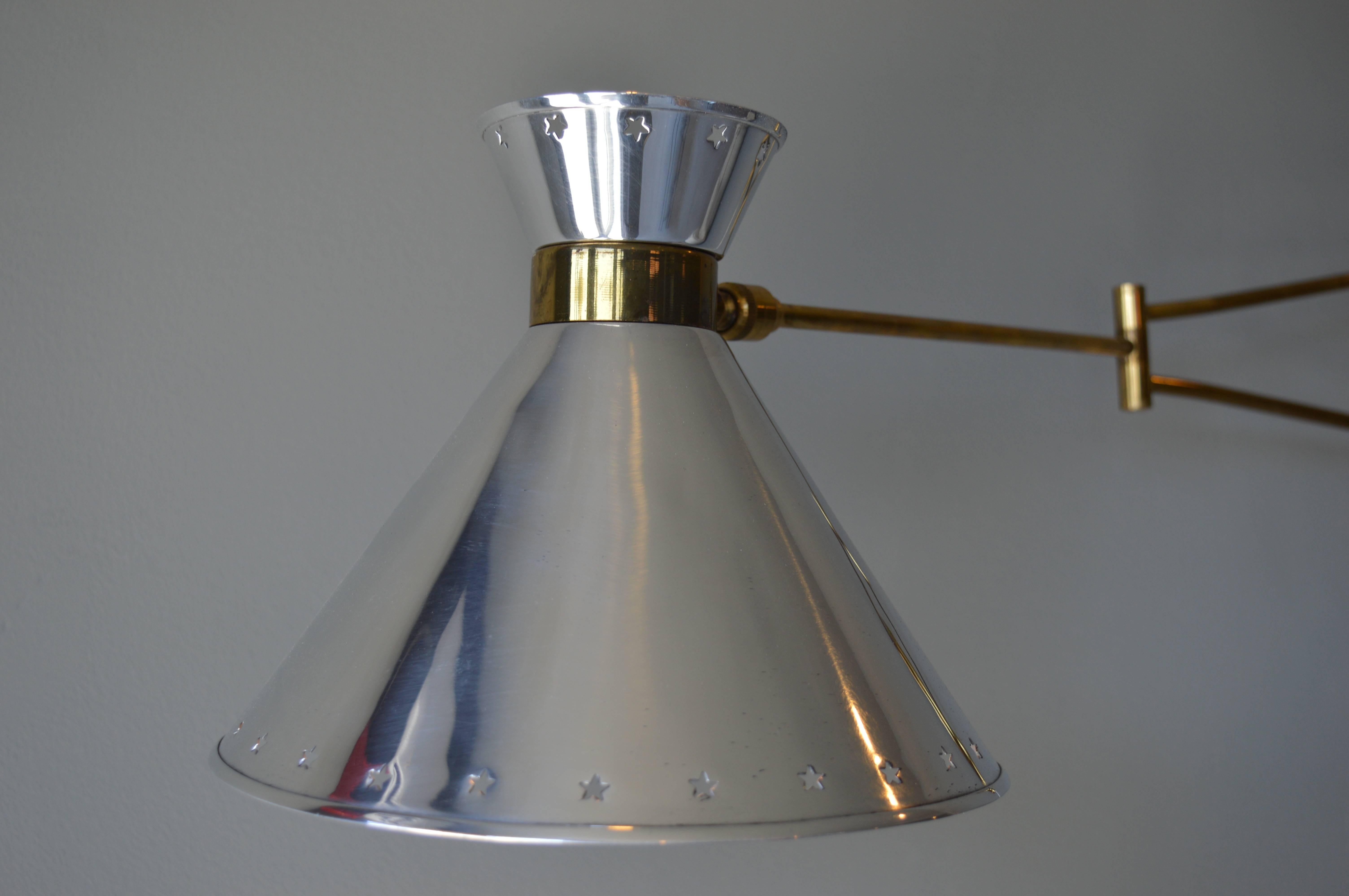 Handsome wall sconce by Lunel. Black backplate, with brass arms and hardware and polished aluminum shade. Newly wired with red cloth cord. Excellent vintage condition.